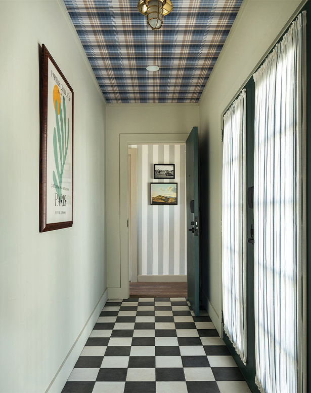 A hallway with a plaid ceiling, checkered floor, and curtained windows.