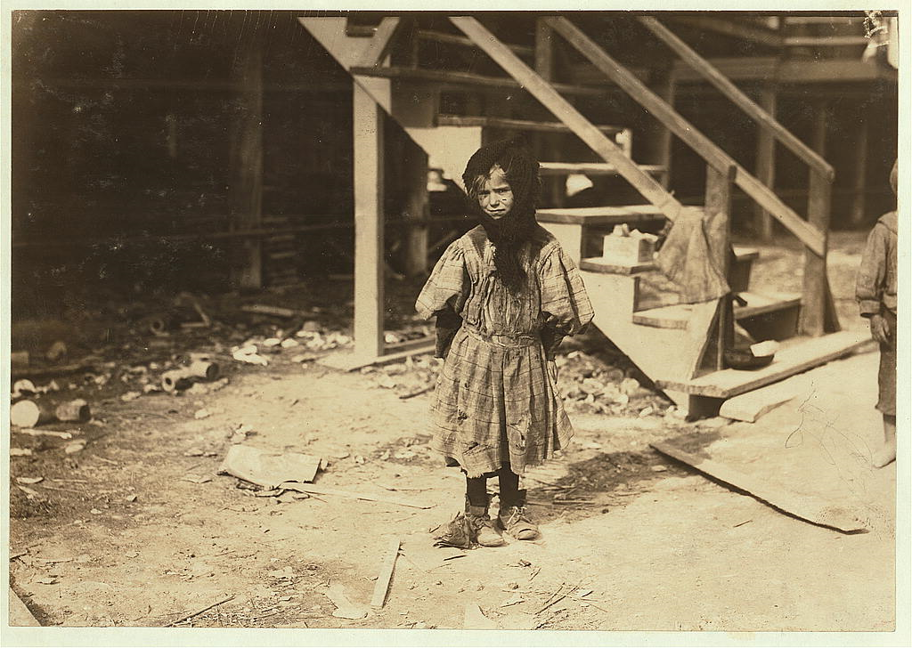 small girl dressed in rags