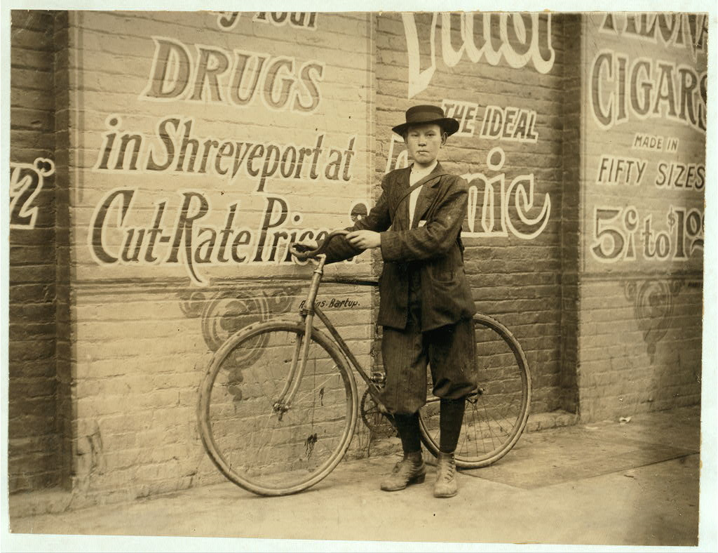 child next to his delivery bicycle