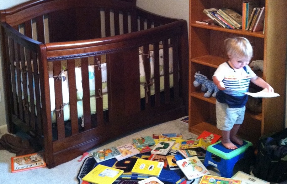 Small child reading alone in a nursery