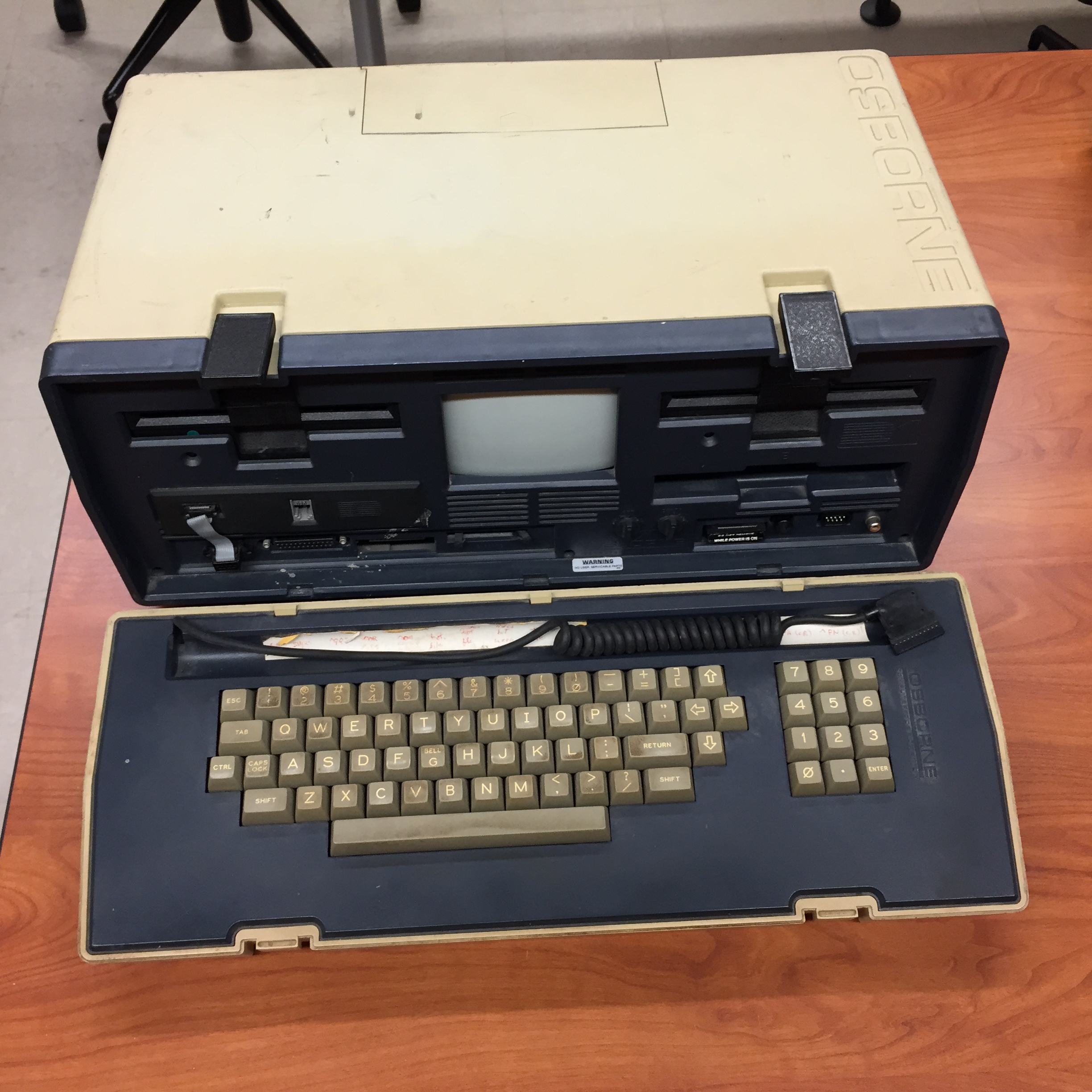 Image of old computer. It's a large container with a small screen in it and a keyboard