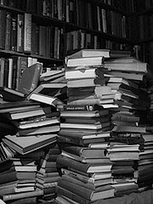 Stacks of books in front of book shelves
