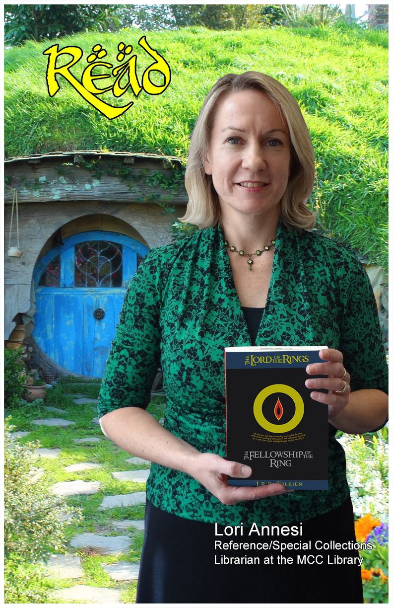 Read poster photo of Lori Annesi looking forward, holding book, wearing green & black print top, black shell, black skirt.