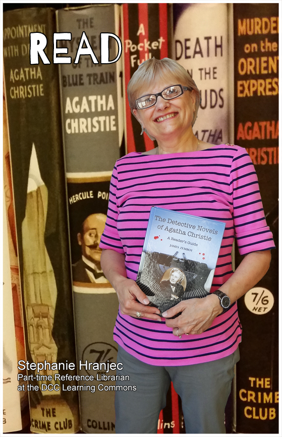 Read poster photo of Stephanie Hranjec looking forward, holding book, wearing glasses, pink & black striped top, gray pants.