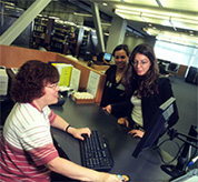 Photo of a librarian helping to students at the King Library