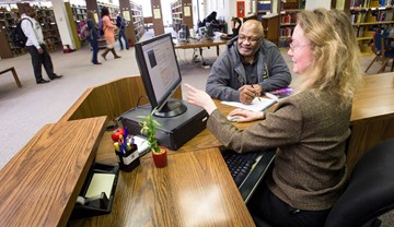 Student looking at information at Reference Desk