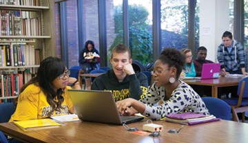 Students looking at information on laptop in ODU Library