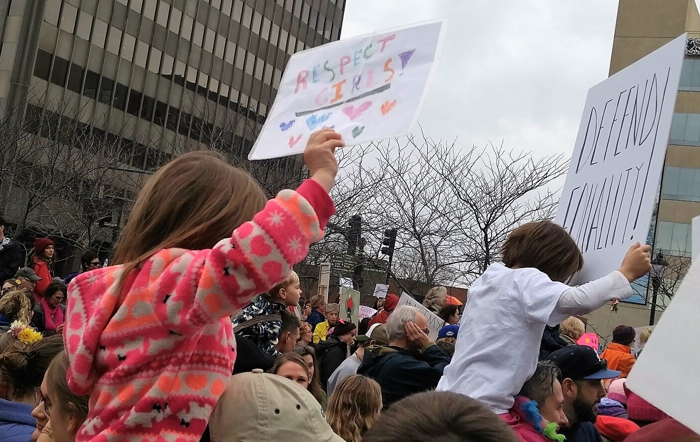 Protesters & children with signs "Respect Girls" "Defend Equality"