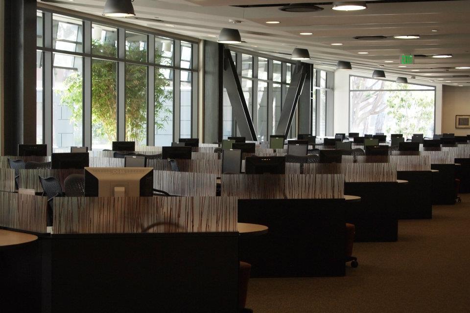 Computer lab with desktops, chargers, and table space on the second floor of Library South.