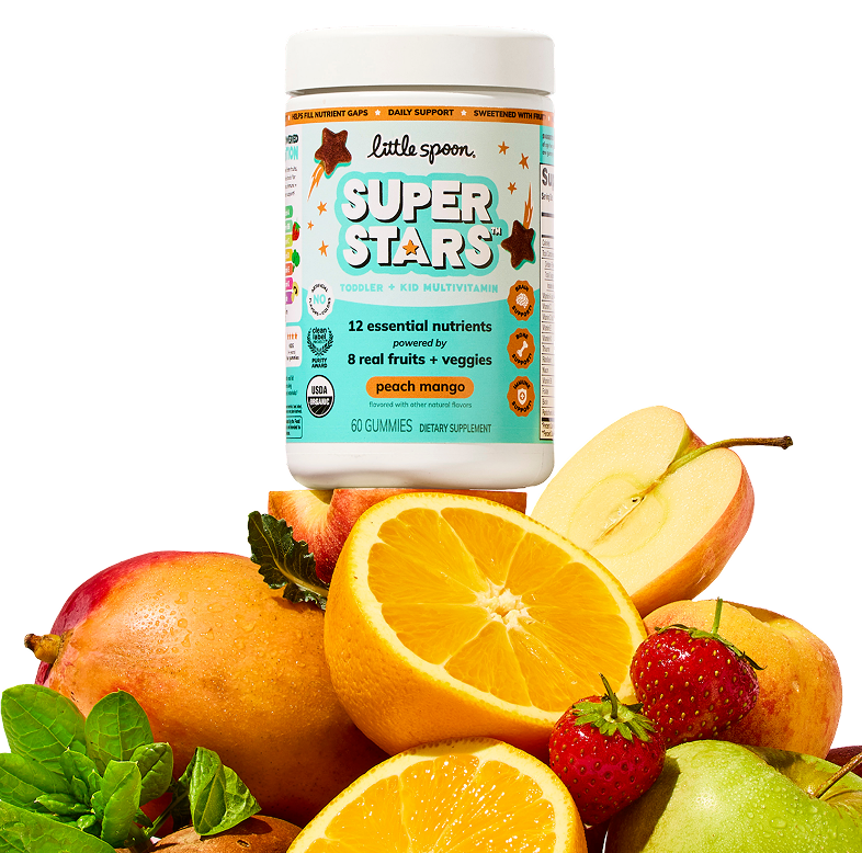 A jar of Little Spoon Superstars peach mango toddler and kid multivitamin gummies surrounded by fresh oranges, mango, apple, strawberries and peach