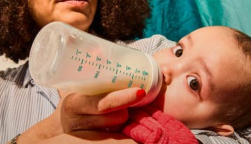 A baby drinking Little Spoon infant formula from a bottle