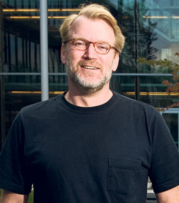 Bruce Lanphear, Clinician Scientist for Early Childhood Health, raising awareness for Little Things Matter, standing outside a modern building, smiling in a black shirt and glasses.