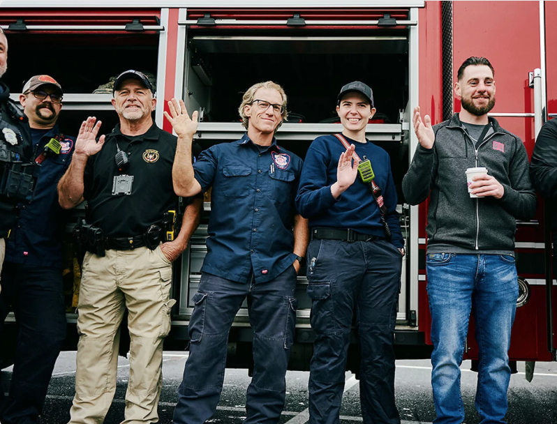 Local first responders waving beside a fire truck at a T-Mobile Hometown Hero Event