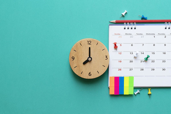Close up of clock and calendar on a wall