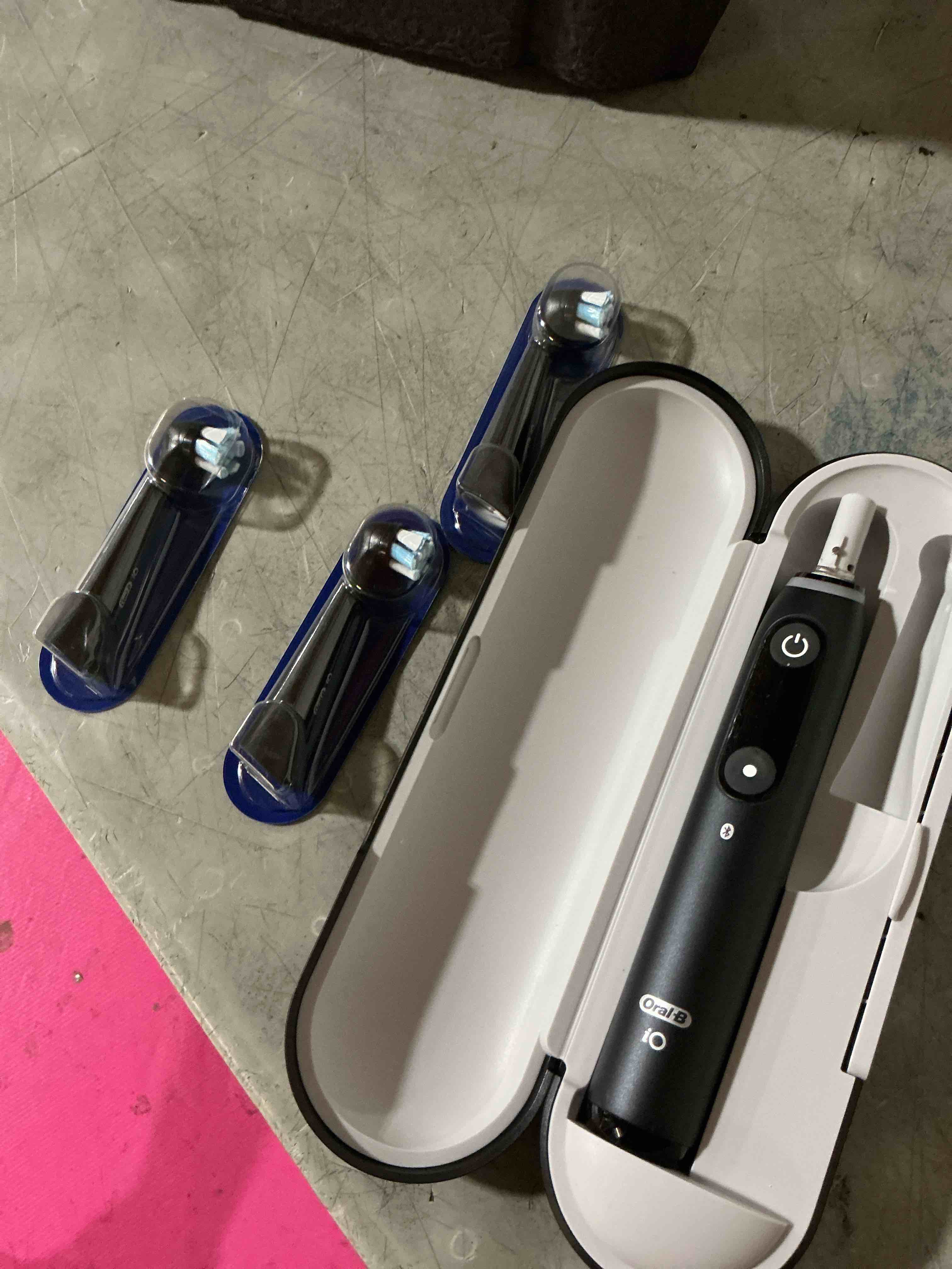 Condition photo showing As Is for (incomplete) oral-b rechargeable electric toothbrush, io9 limited ultimate clean, 7 cleaning modes, interactive display, isense charger, charging travel case, visible pressure sensor, 3 brush heads, black