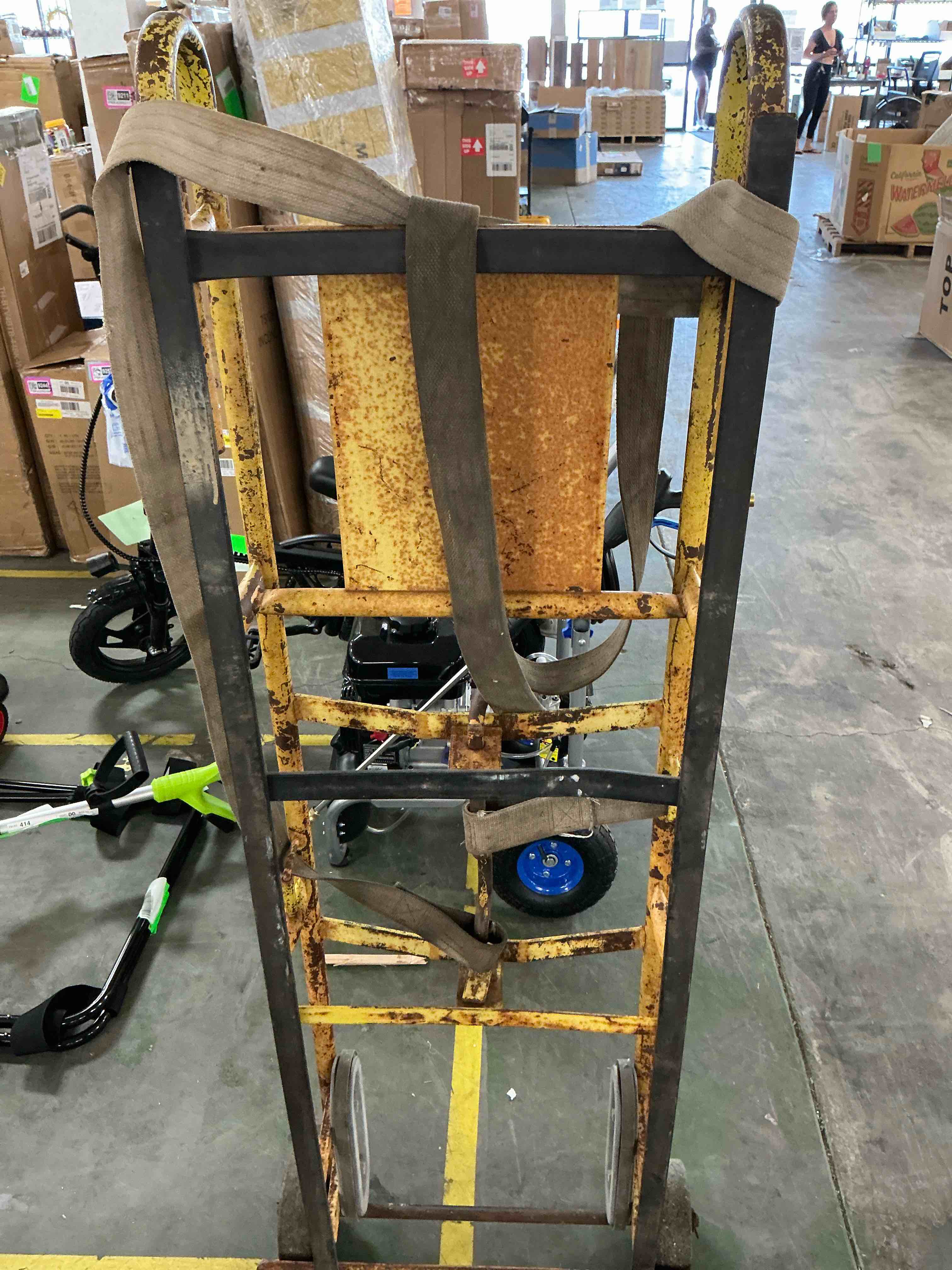 Condition photo showing As Is for strongway industrial hand truck, 1200-lb capacity heavy-duty appliance dolly, convertible 2 or 4 wheel design, 8-inch rubberized wheels with auto-rewind ratchet belt, model 67969