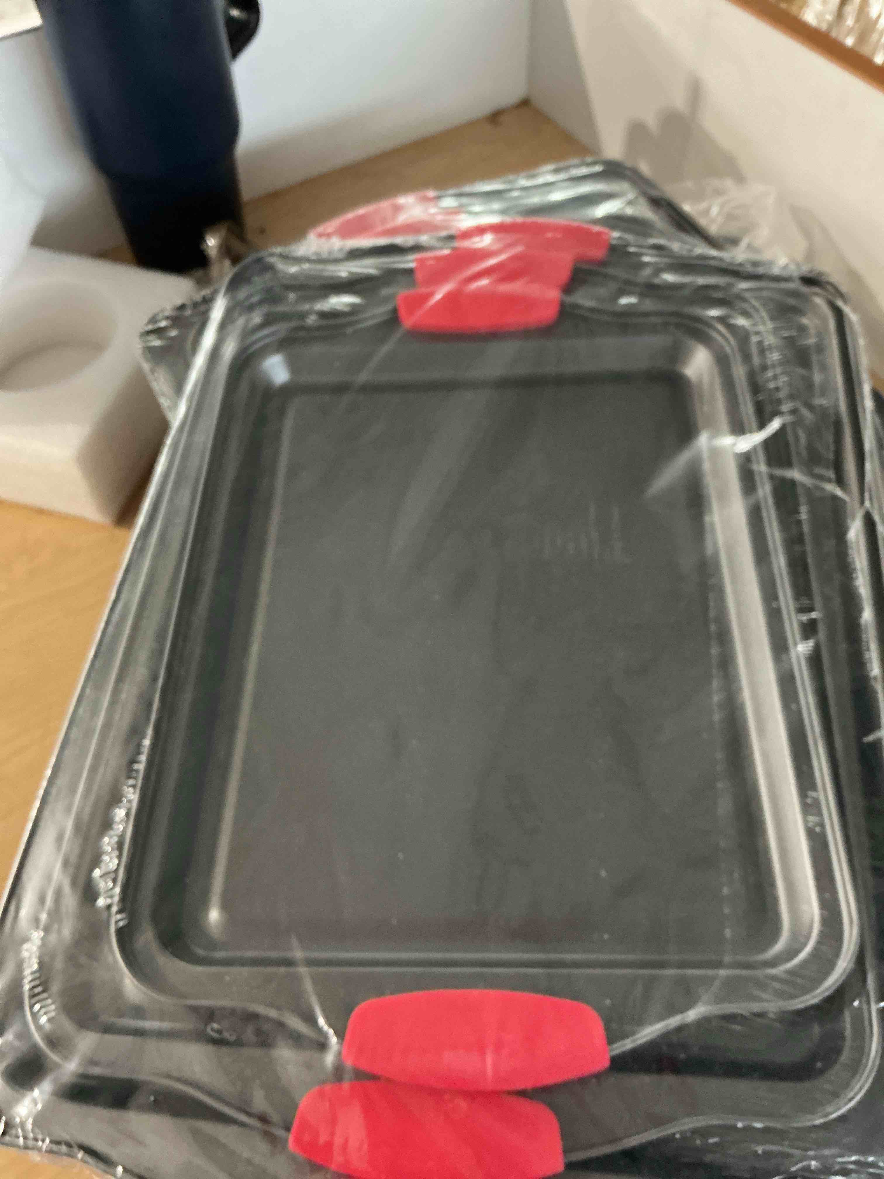 Condition photo showing New/Like New for nutrichef nonstick baking pans set – 3-piece carbon steel cookie sheet set with red silicone handles, small, medium, large stackable trays, oven and dishwasher safe design for cakes, cookies and more