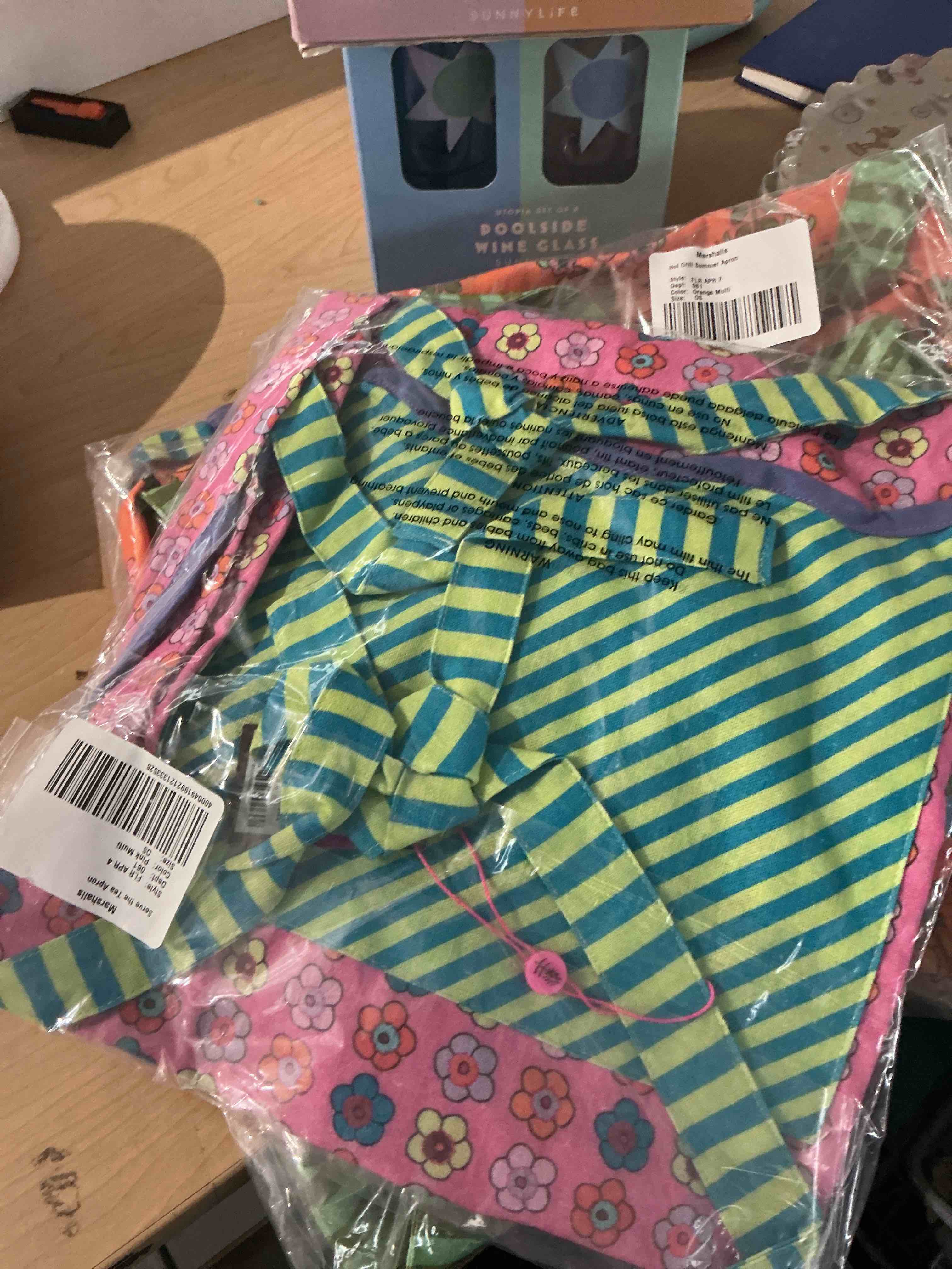Condition photo showing New/Like New for vibrant, pink retro style formal kitchen, apron featuring embroidered text that reads i can’t cook, but i can serve the tea shades of orange, purple, blue, and yellow, detailed with a cling purple roller trim near the bottom