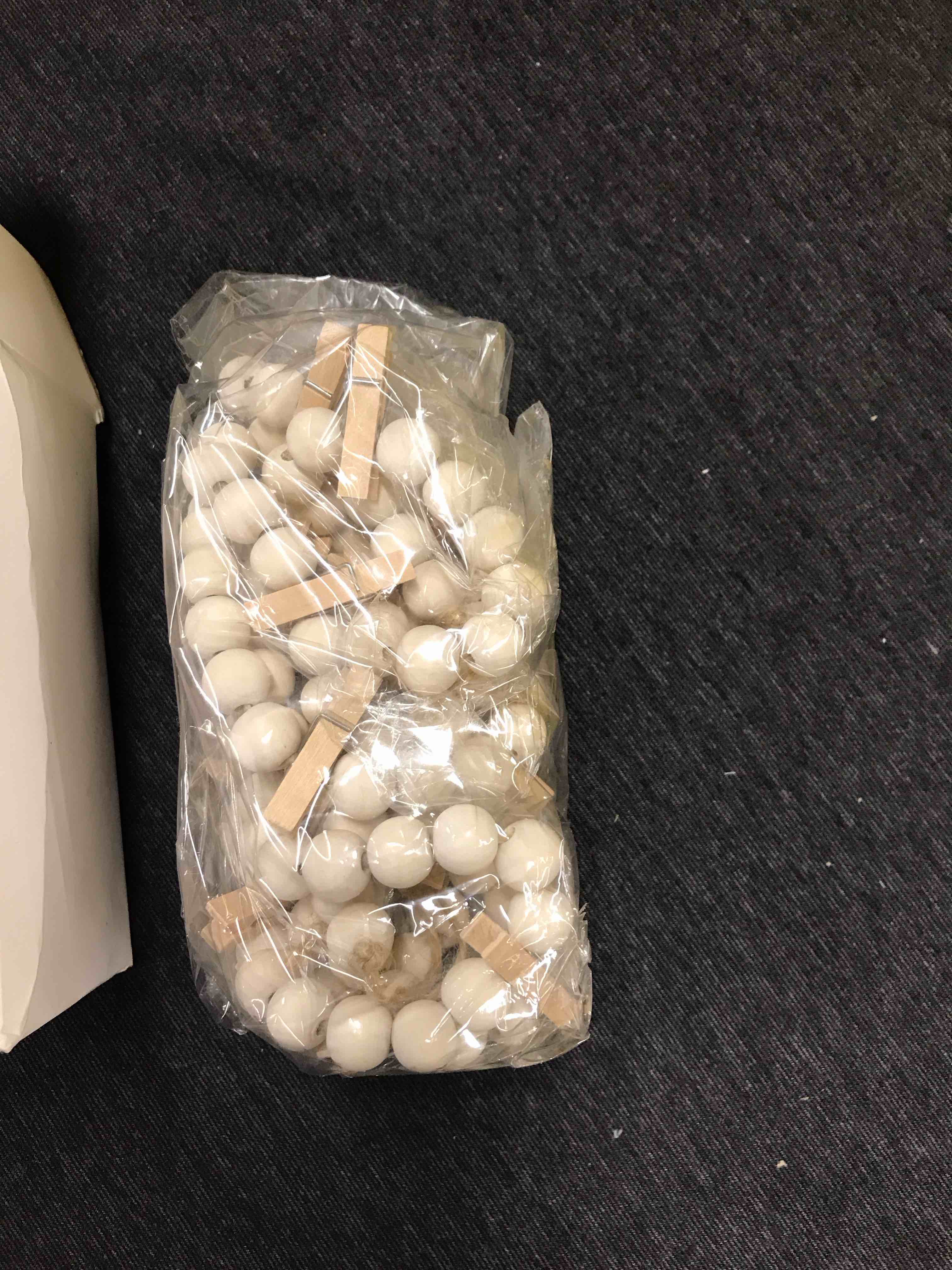 String beads with clothes pins to hang pictures