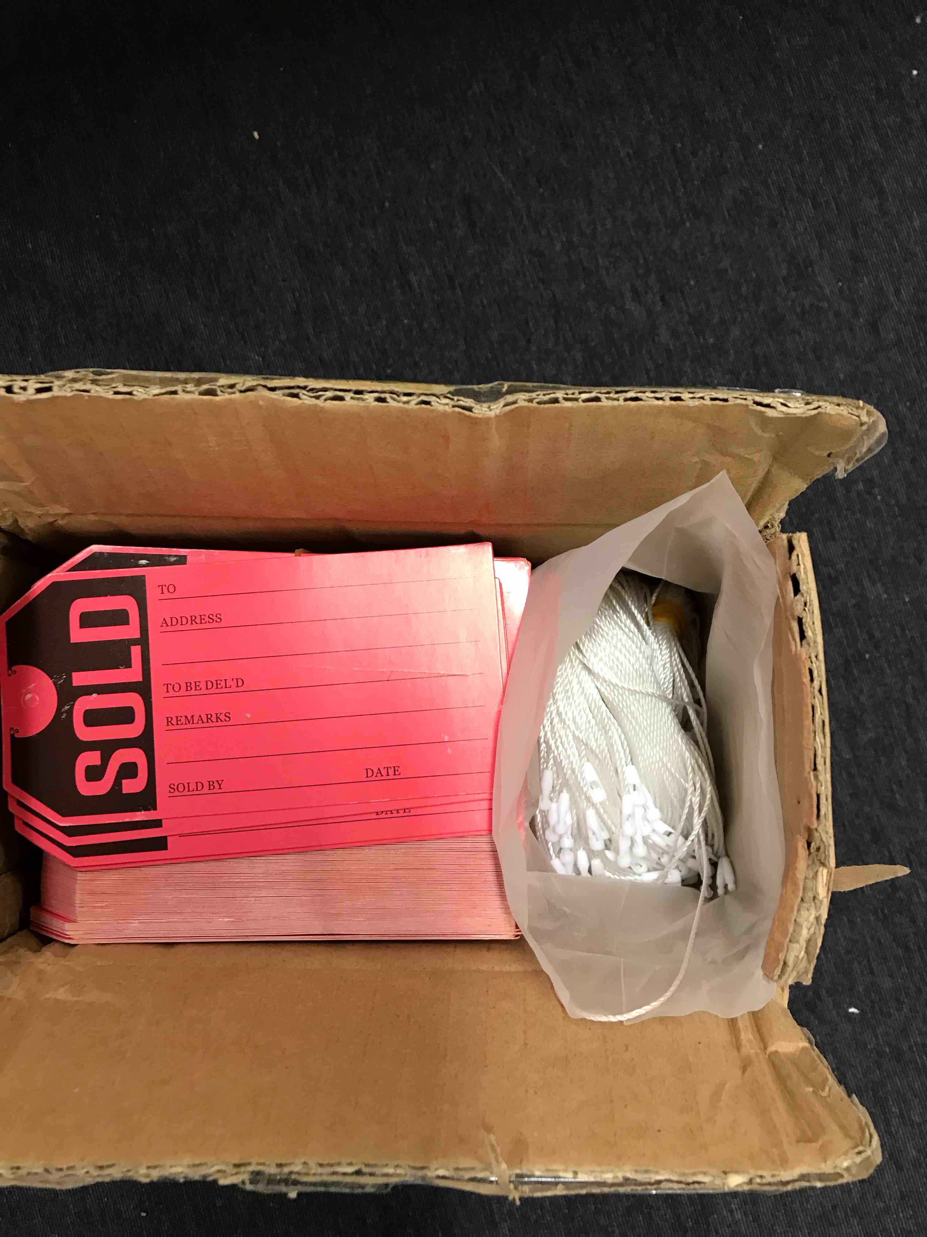 Box of sold tags with string