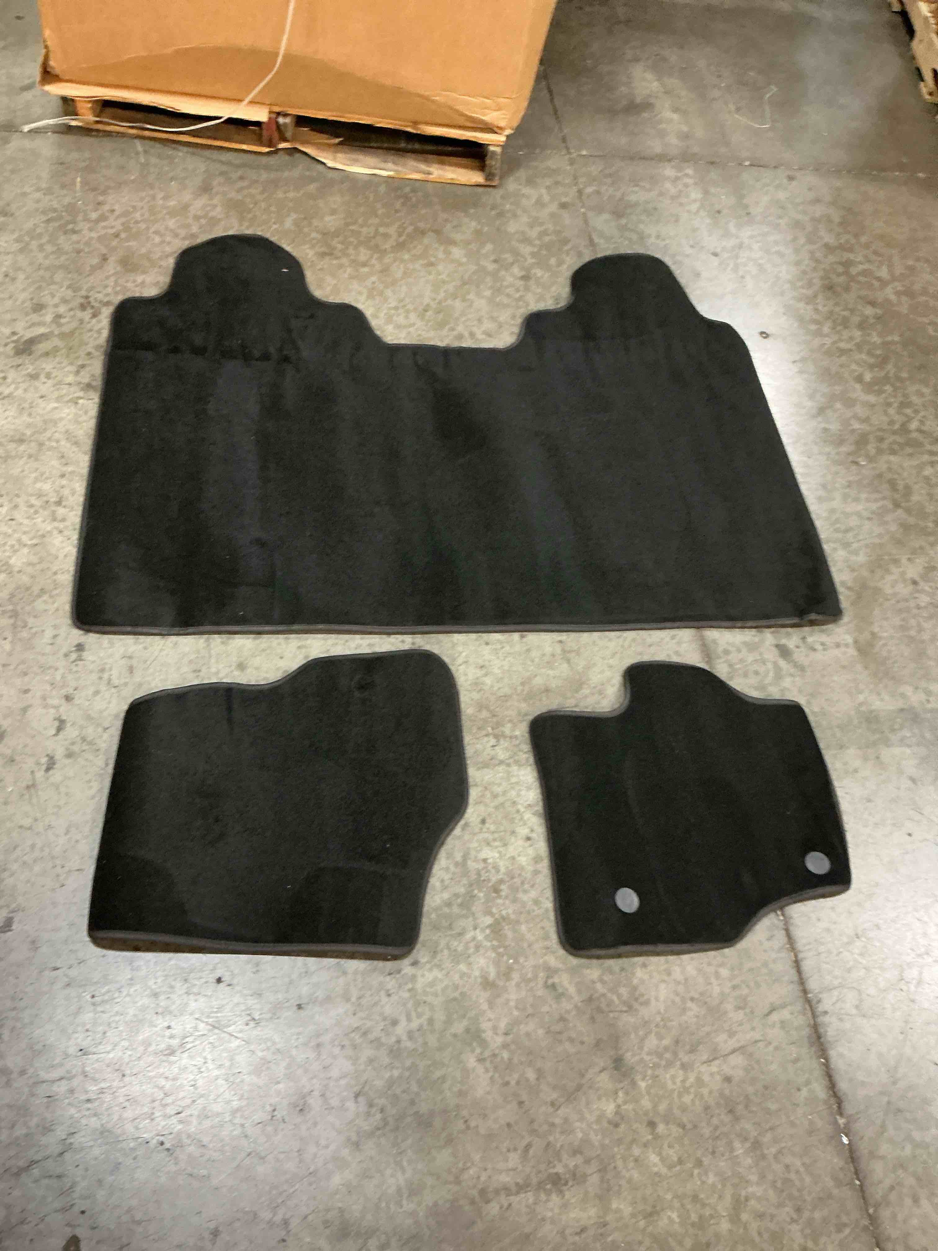 Condition photo showing Good Condition for displays a 3-piece black carpeted vehicle floor mat set featuring a large rear full-coverage runner and two front individual mats with secure retention grommets