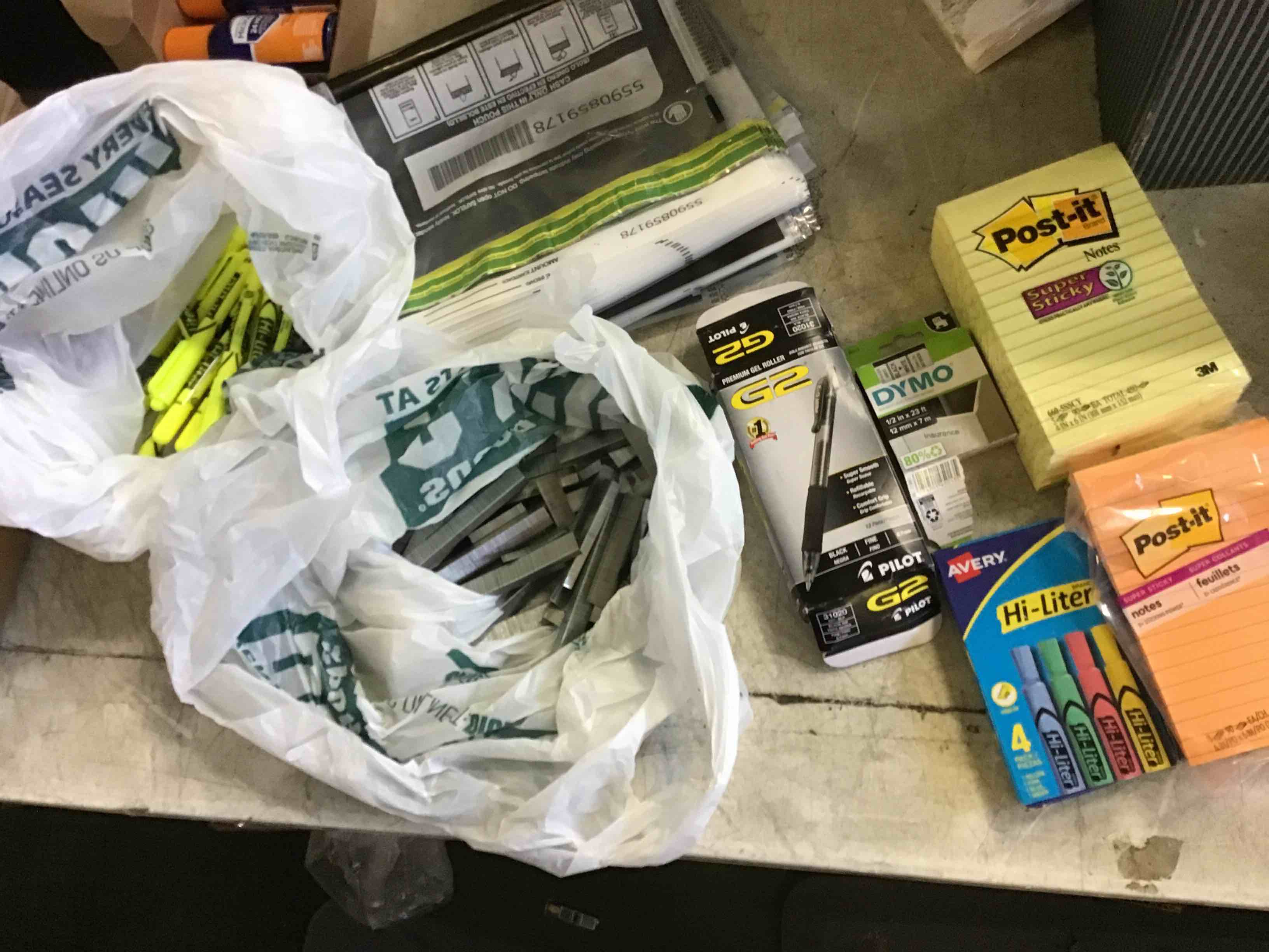 assorted office & school supplies (money bags) (2 pk of post it pads) ( 1 Avery highlighters) (1 dymo) (1 pk of pens) (1 bag of staples) (1 bag of highway