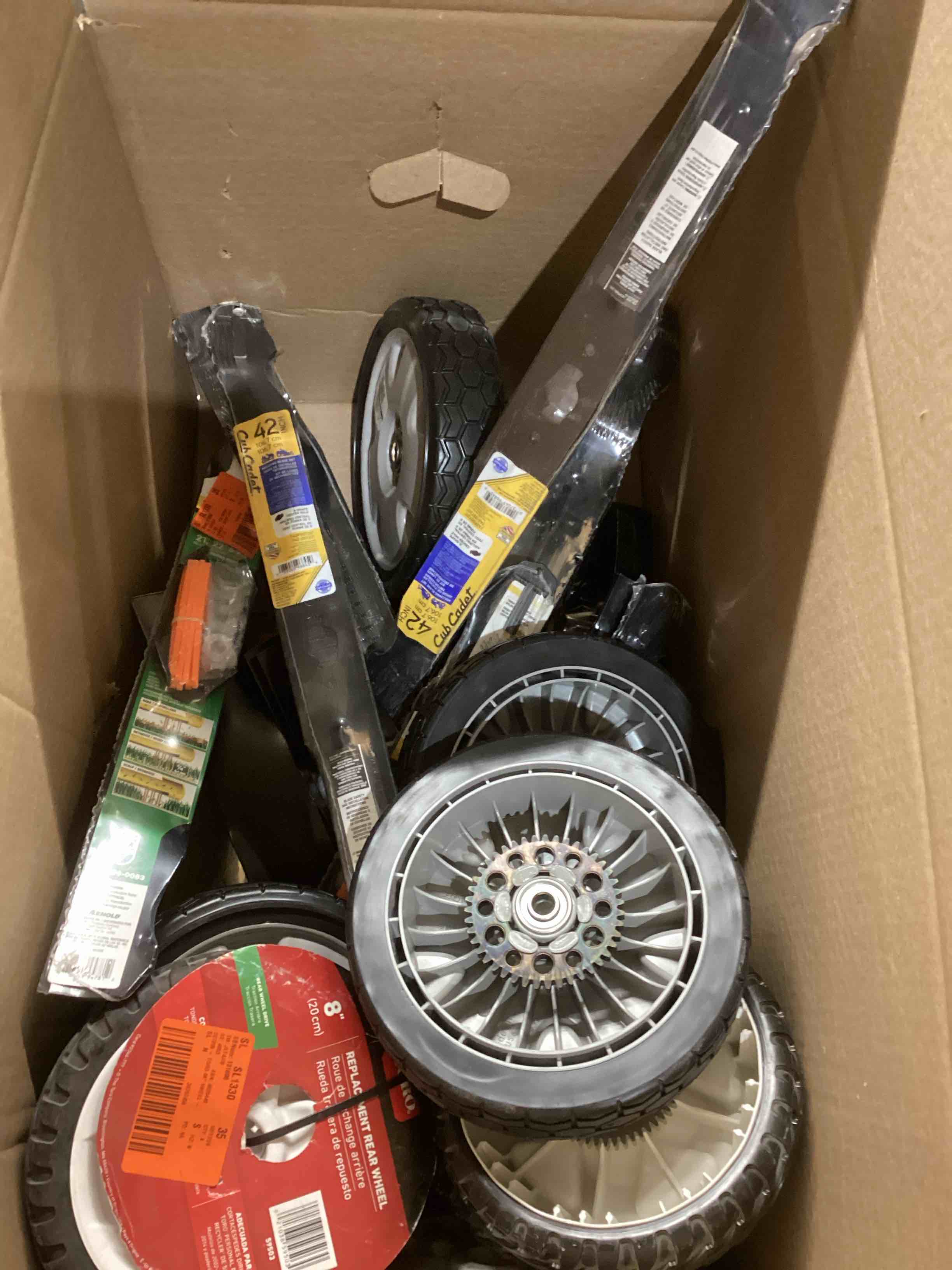 assortment of lawnmower, blades, and wheels 