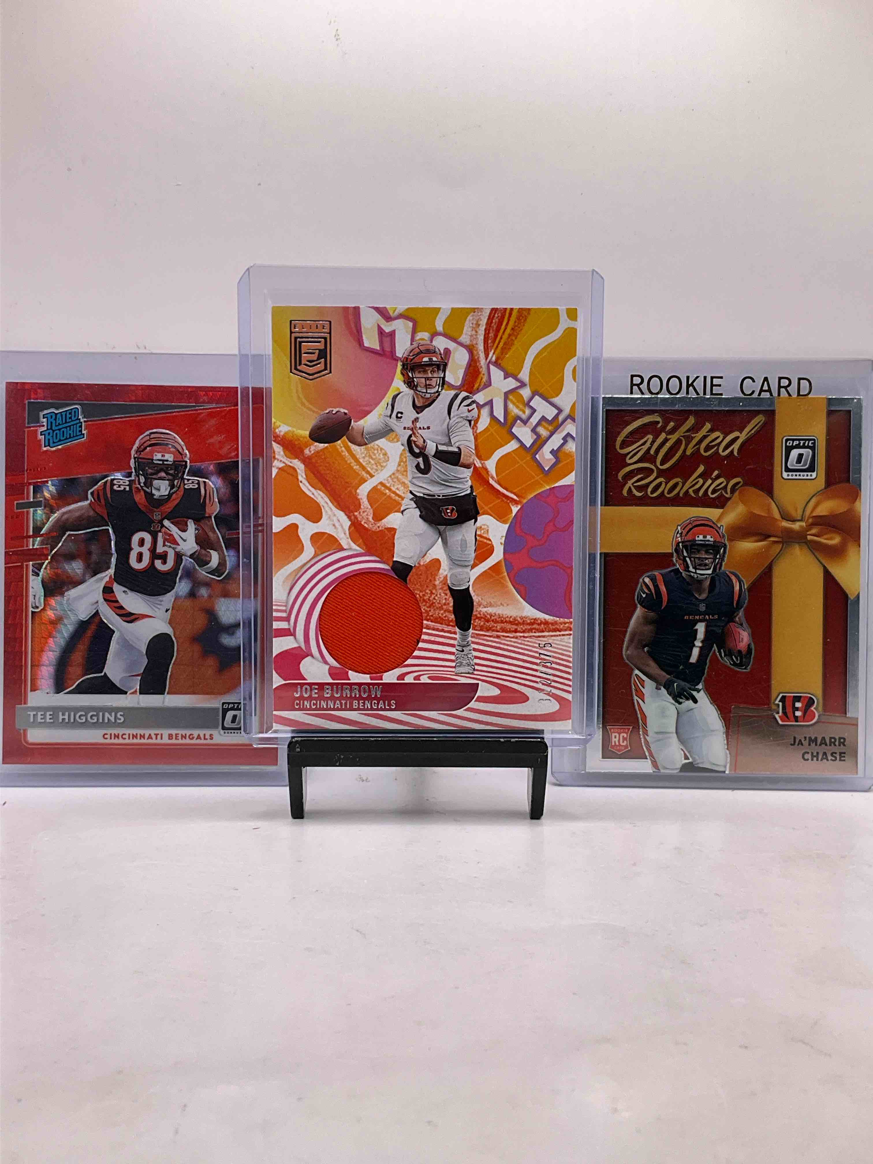 Joe Burrow Elite Moxey Jersey Swatch /375, Snakeskin Refractor Optic Tee Higgins Rated Rookie Red & Ja’marr Chase Optic Gifted Rookies Rookie Card, Along With Many Vintage & New Bengals! 50 Card Bengals!