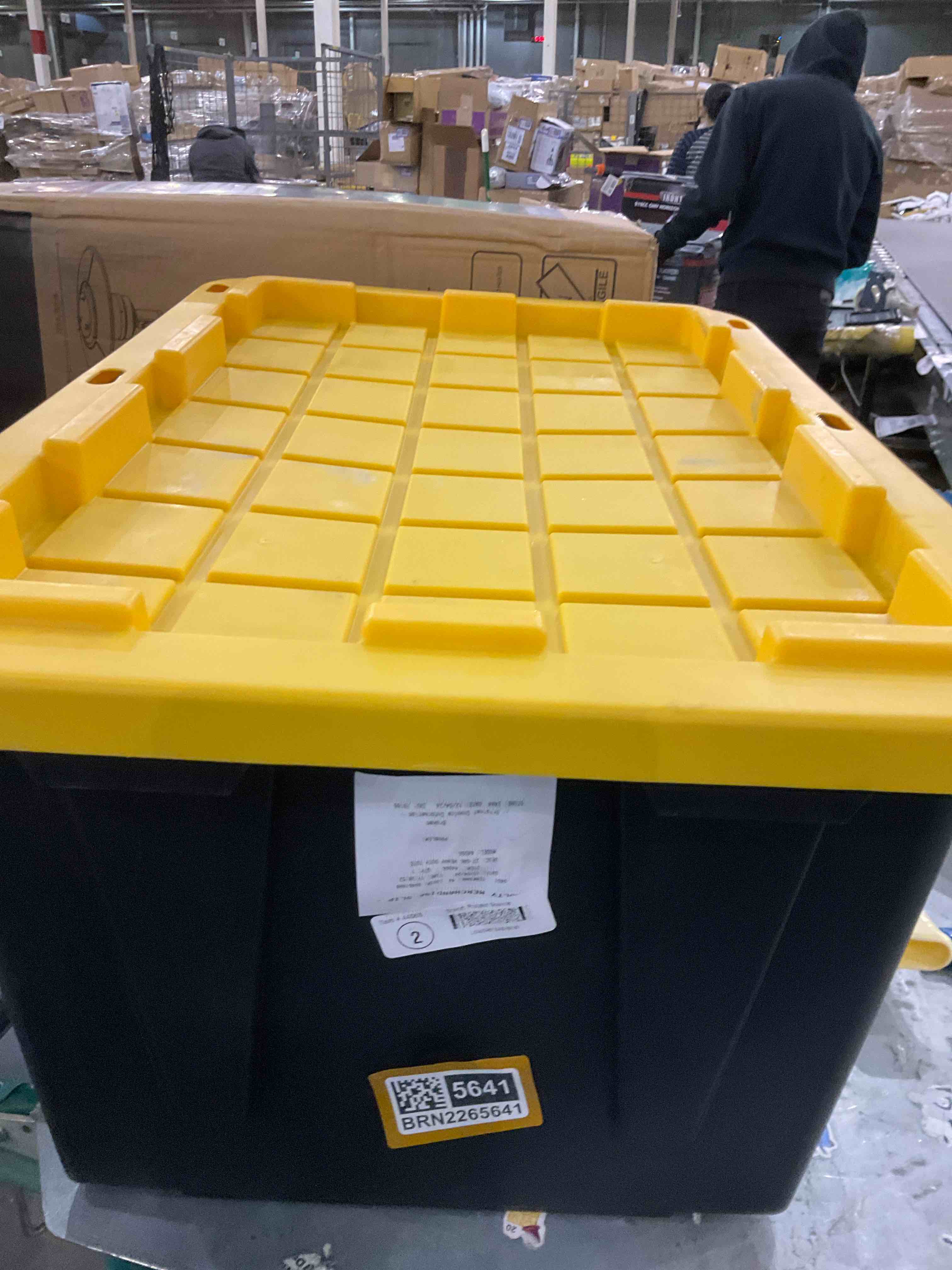 27-Gallon Black Heavy Duty Tote with a yellow lid. It is designed for tough storage and organization needs.