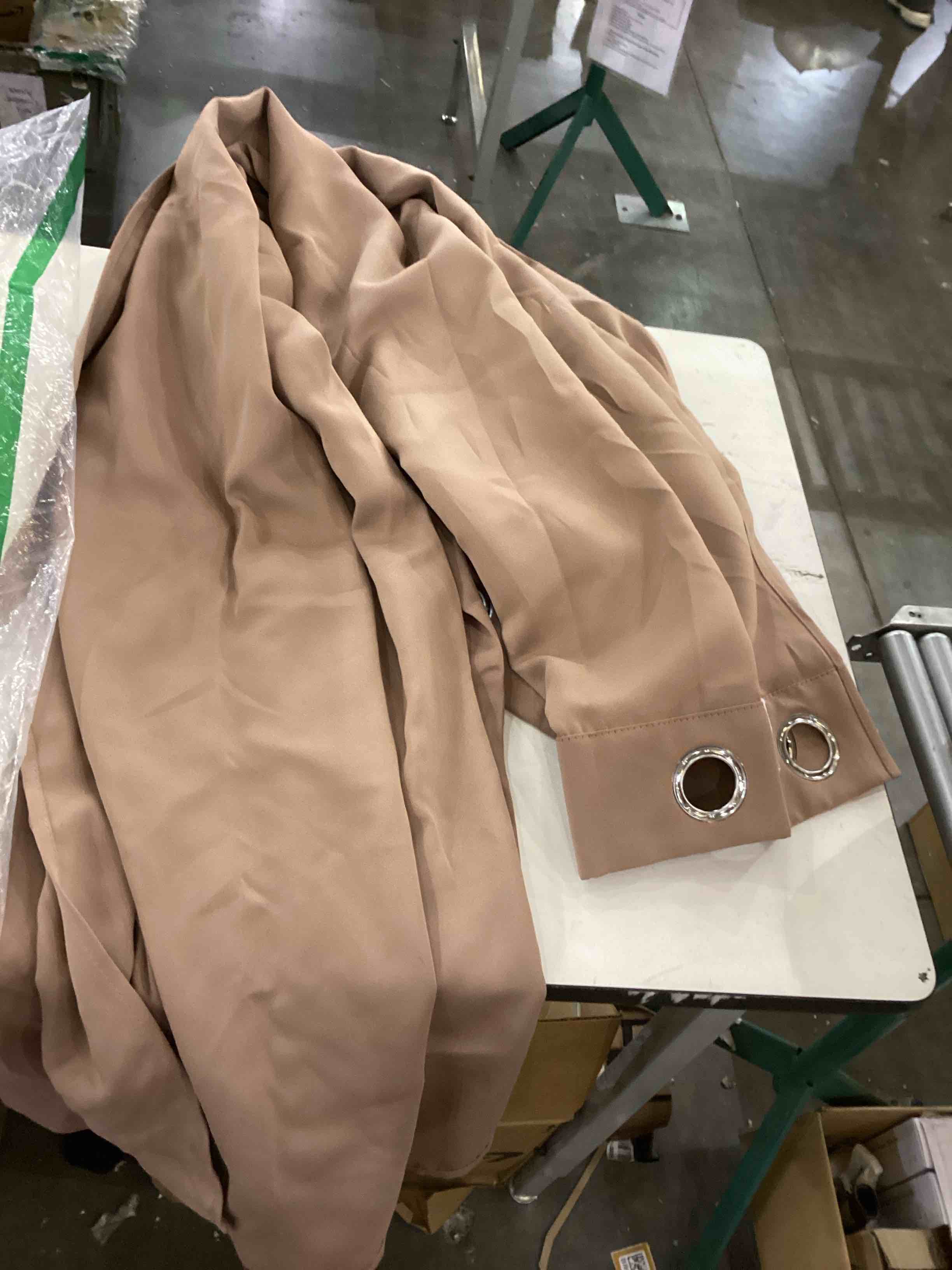 a beige curtain with metal grommets.