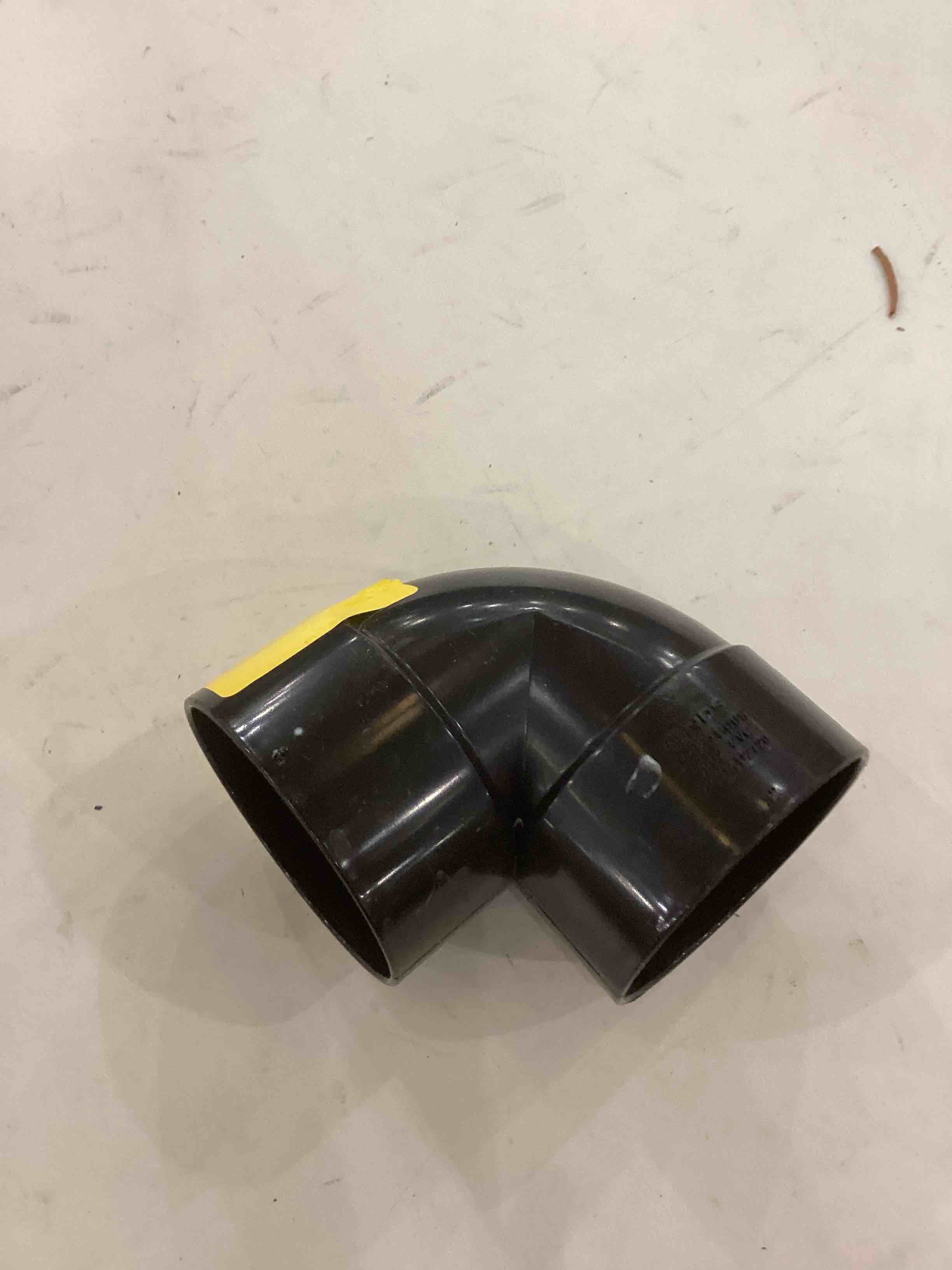 ABS (Acrylonitrile Butadiene Styrene) DWV (Drain, Waste, and Vent) 90-degree elbow fitting.  