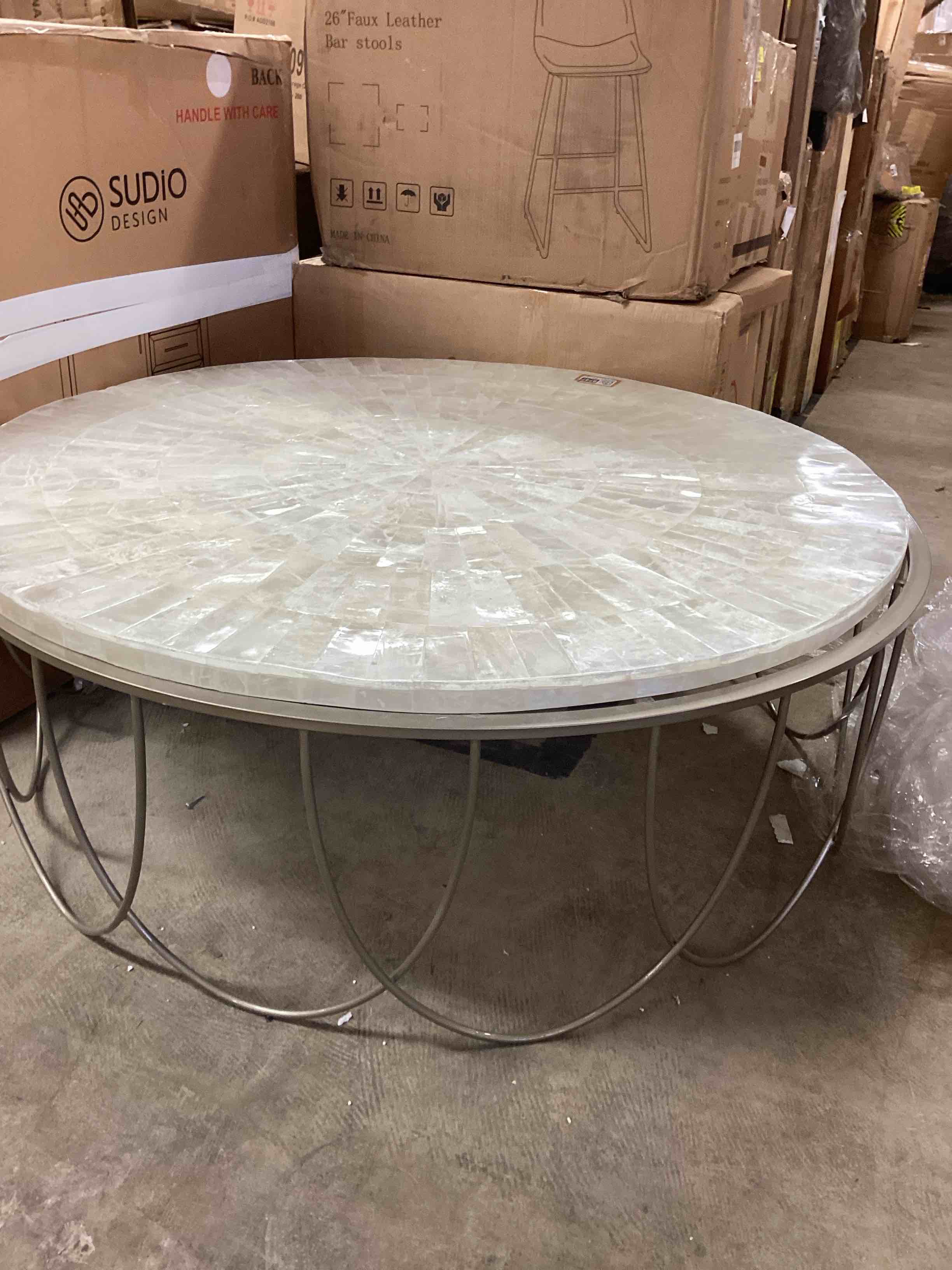 Condition photo showing As Is for PFC Living Room Round Stone Top Cocktail Table with Decorative Metal Base P301743 at Burke Furniture Inc.