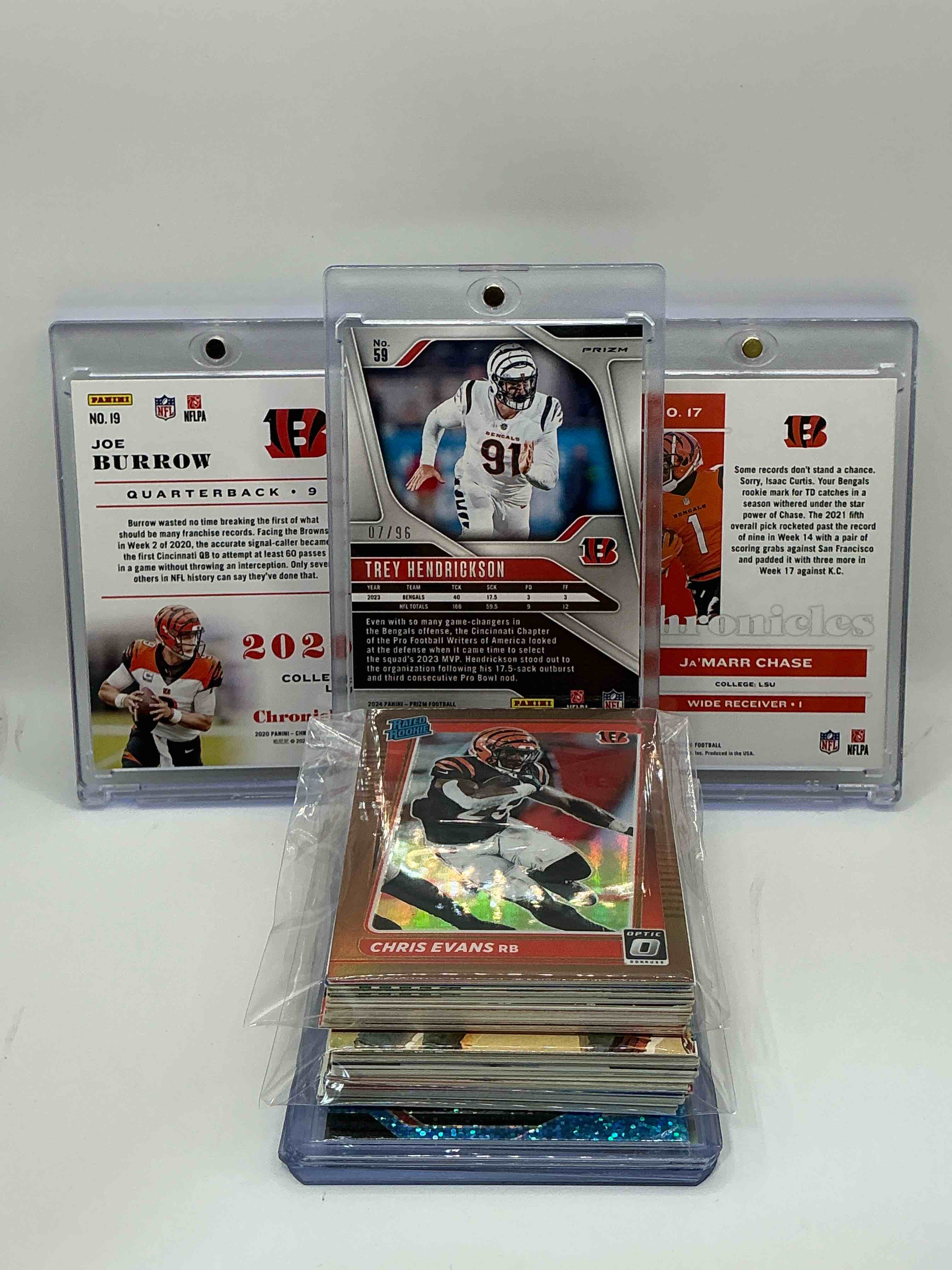 Condition photo showing New/Like New for Bengals Bonanza! 2024 Prizm Blue Disco Trey Hendrickson Numbered 07/96! 2020 Panini Chronicles Rookie Joe Burrow! 2021 Panini Chronicles Rookie Ja’marr Chase! Along With 50 Other Bengals Heroes, Legends, Rookies & Commons!