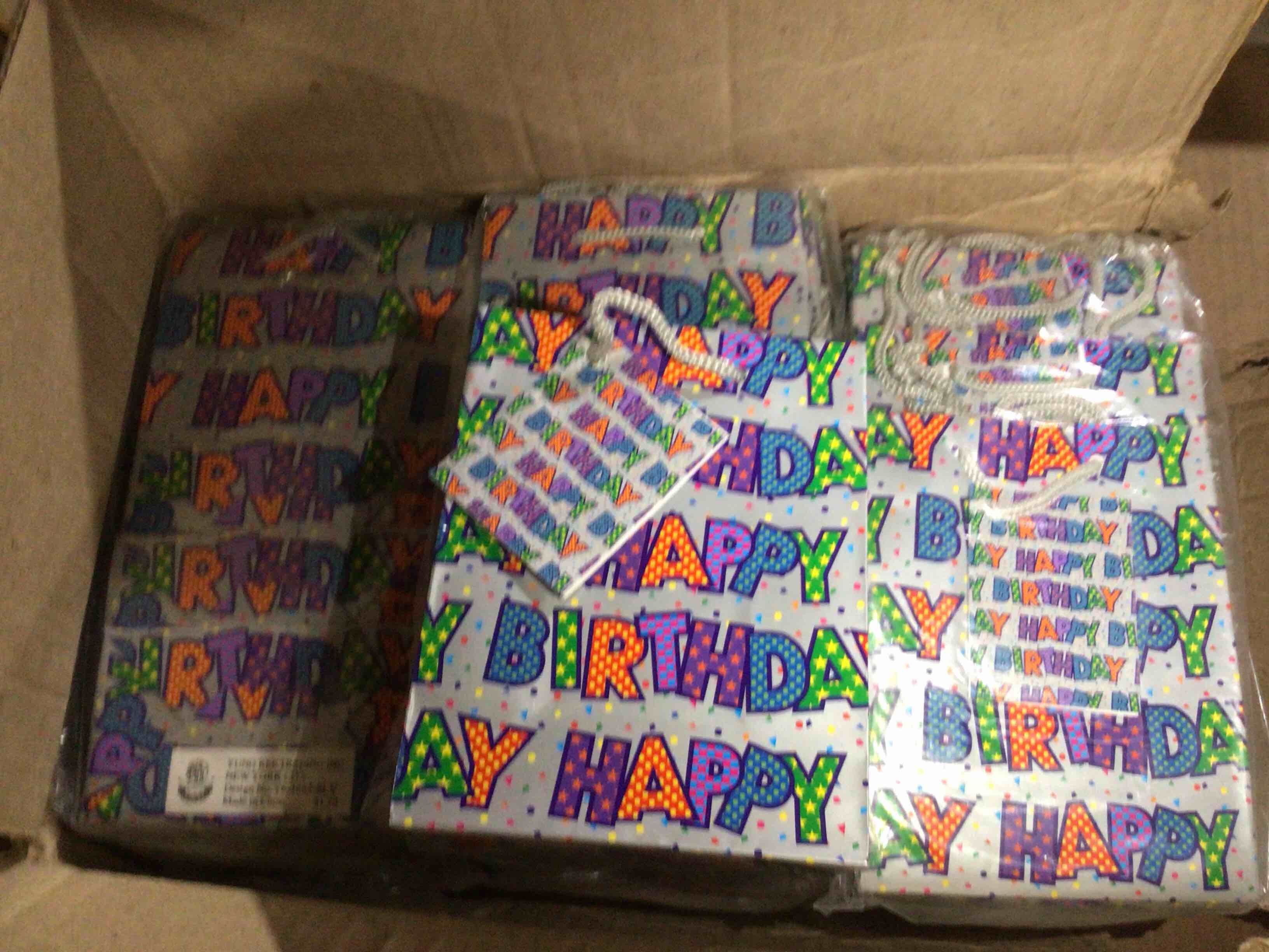 Gift  bags in the image repeatedly say happy birthday 