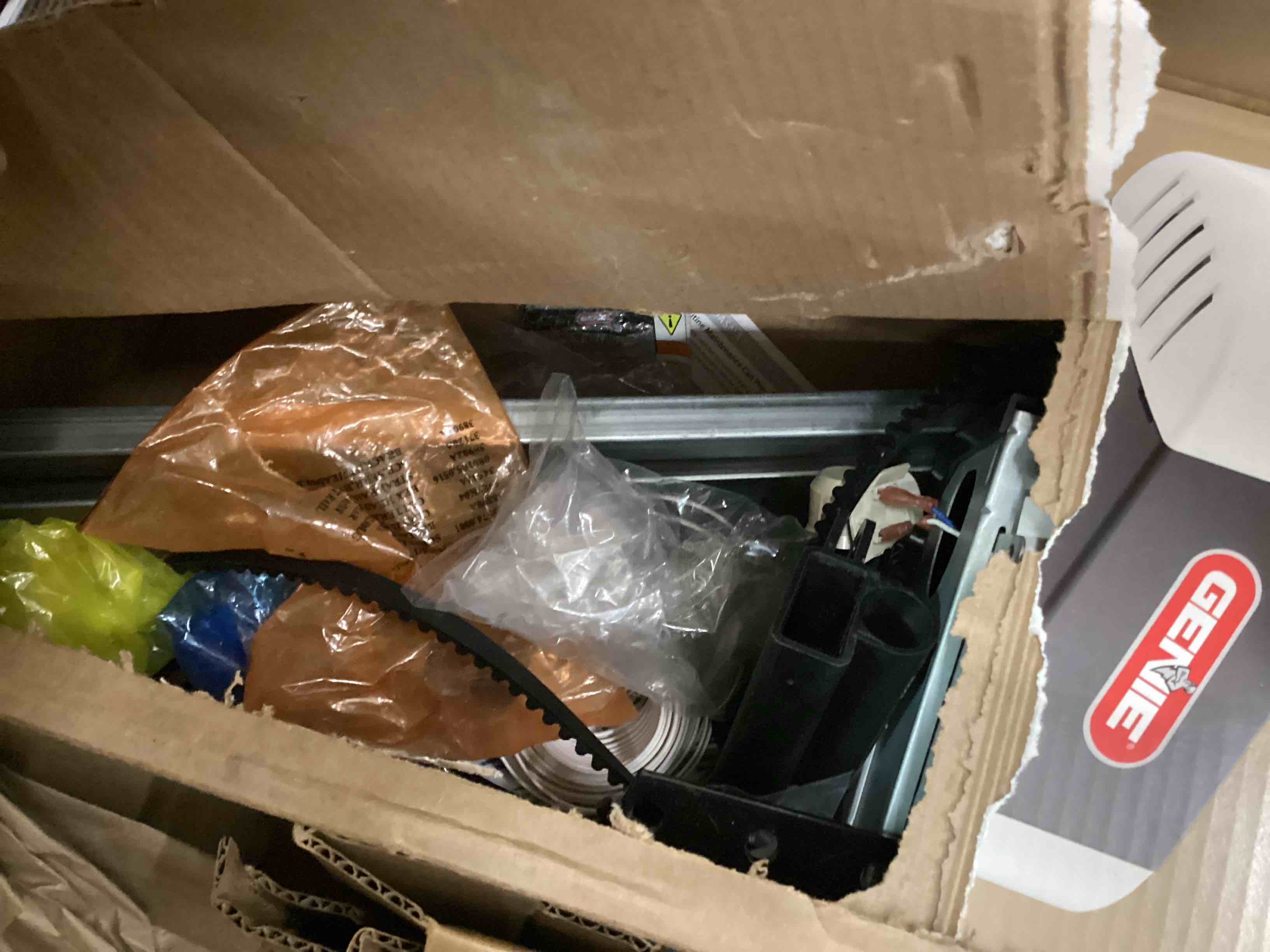Condition photo showing As Is for Genie Chain Drive 750 Garage Door Opener with Battery Backup, Surge Protector and one Single Button Garage Door Remote One remote & surge protector