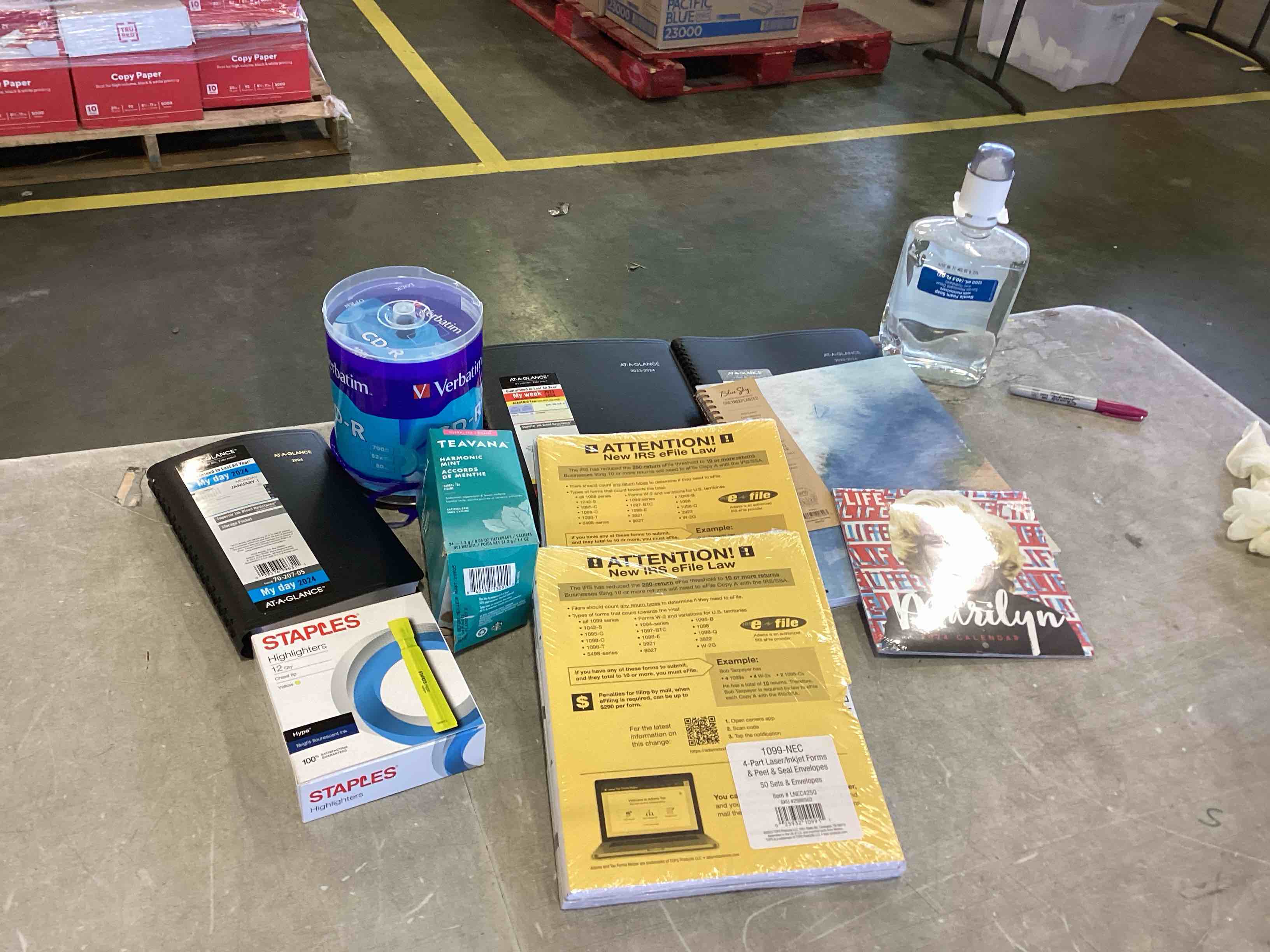 box of assorted office supplies, including highlighters, planners CDR’s, and more