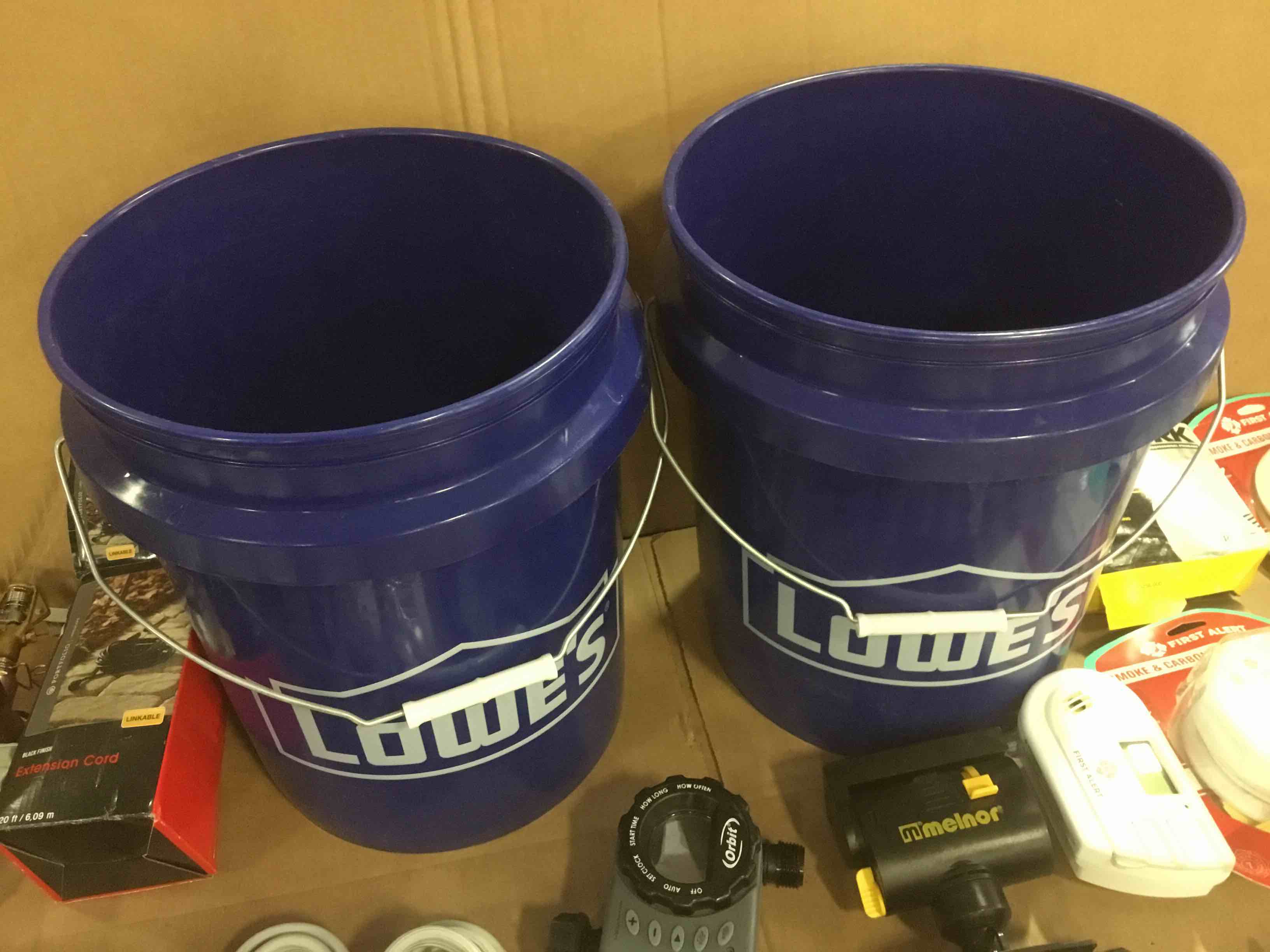 Assorted maintenance or repair supplies: buckets, smoke and carbon monoxide alarms, air conditioner cords, sprinklers, extension cord and more