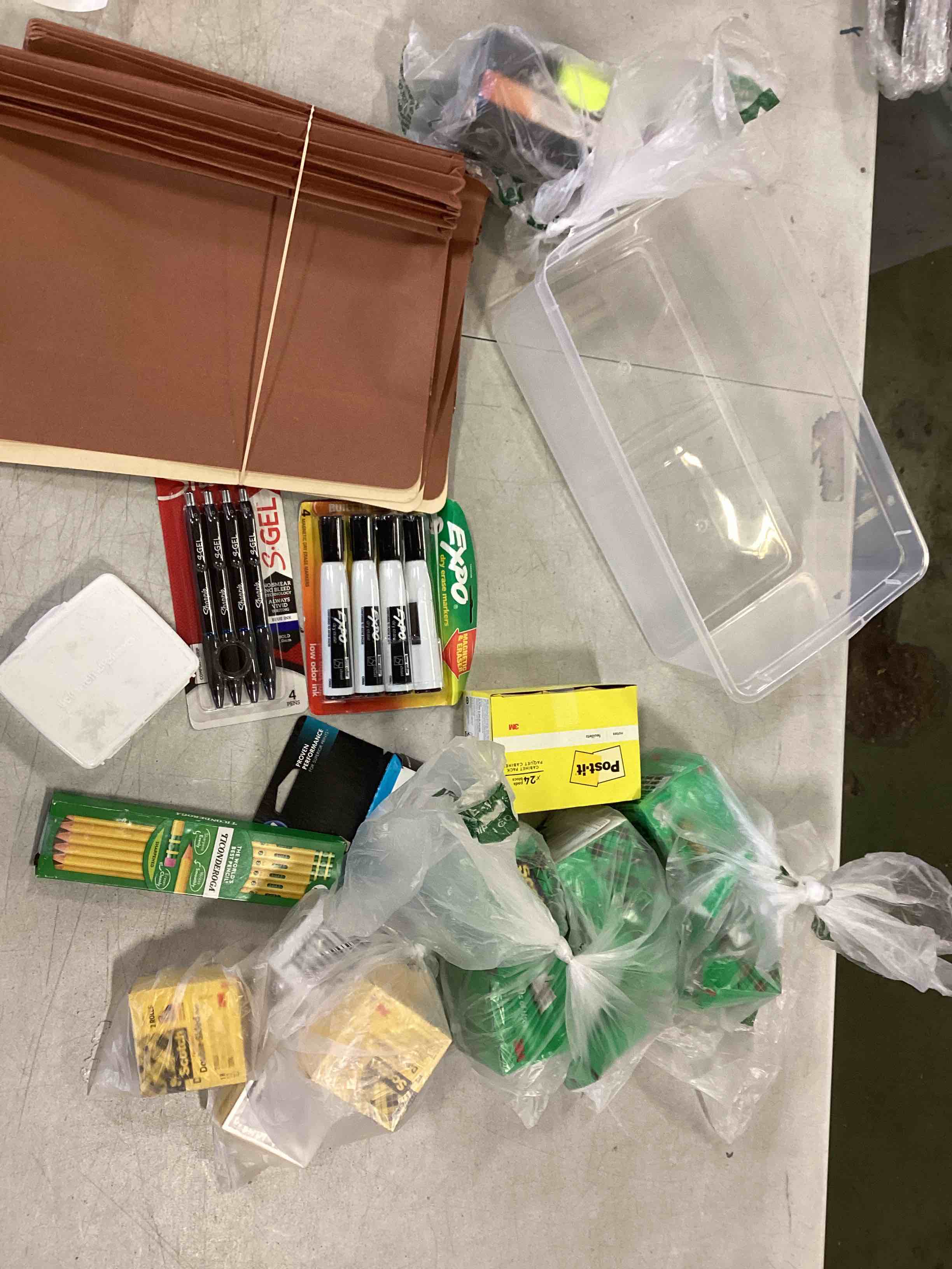 Assorted office supplies such as Expo dry erase markers, pencils, pens bandage kit, file folders, clear bin, various diff. scotch tape, etc 