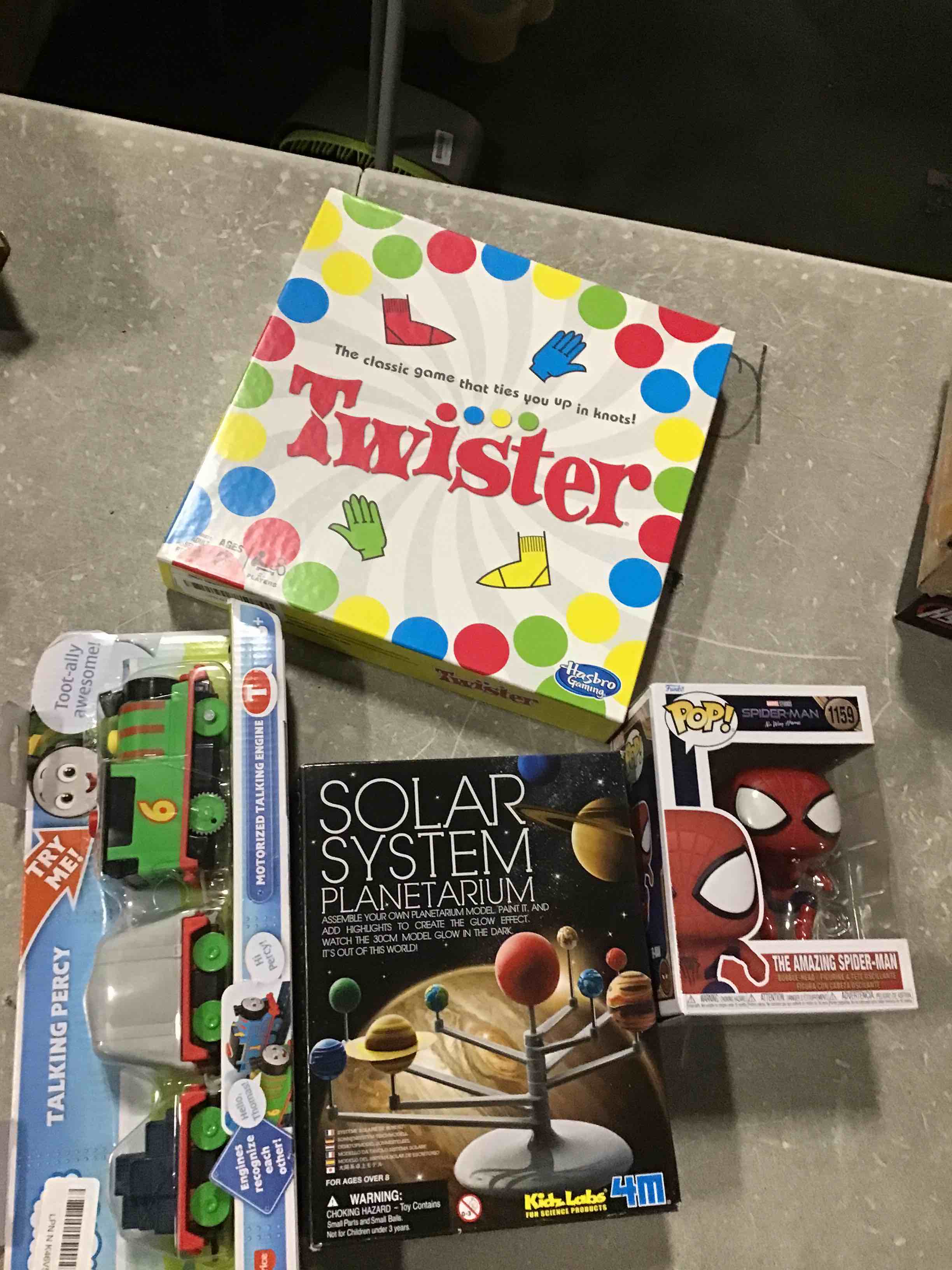 Assorted of children’s toys for different ages includes Funki Pop Spider man, The Classic Twister Game, Talkin Percy Try Me, Solara System Planetarium