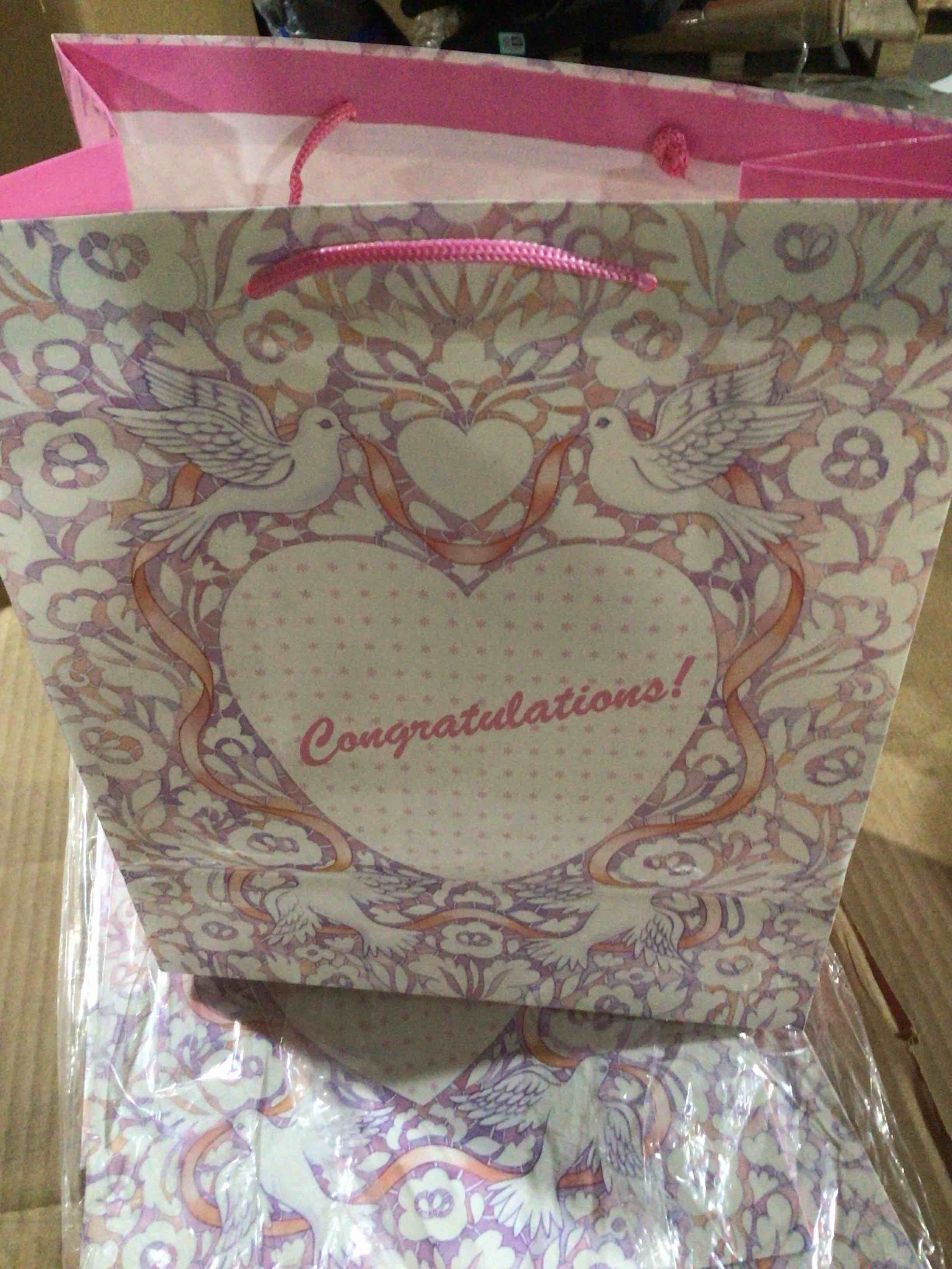 Gift bag with the word “ congratulations' ) in the center of a decorative design.