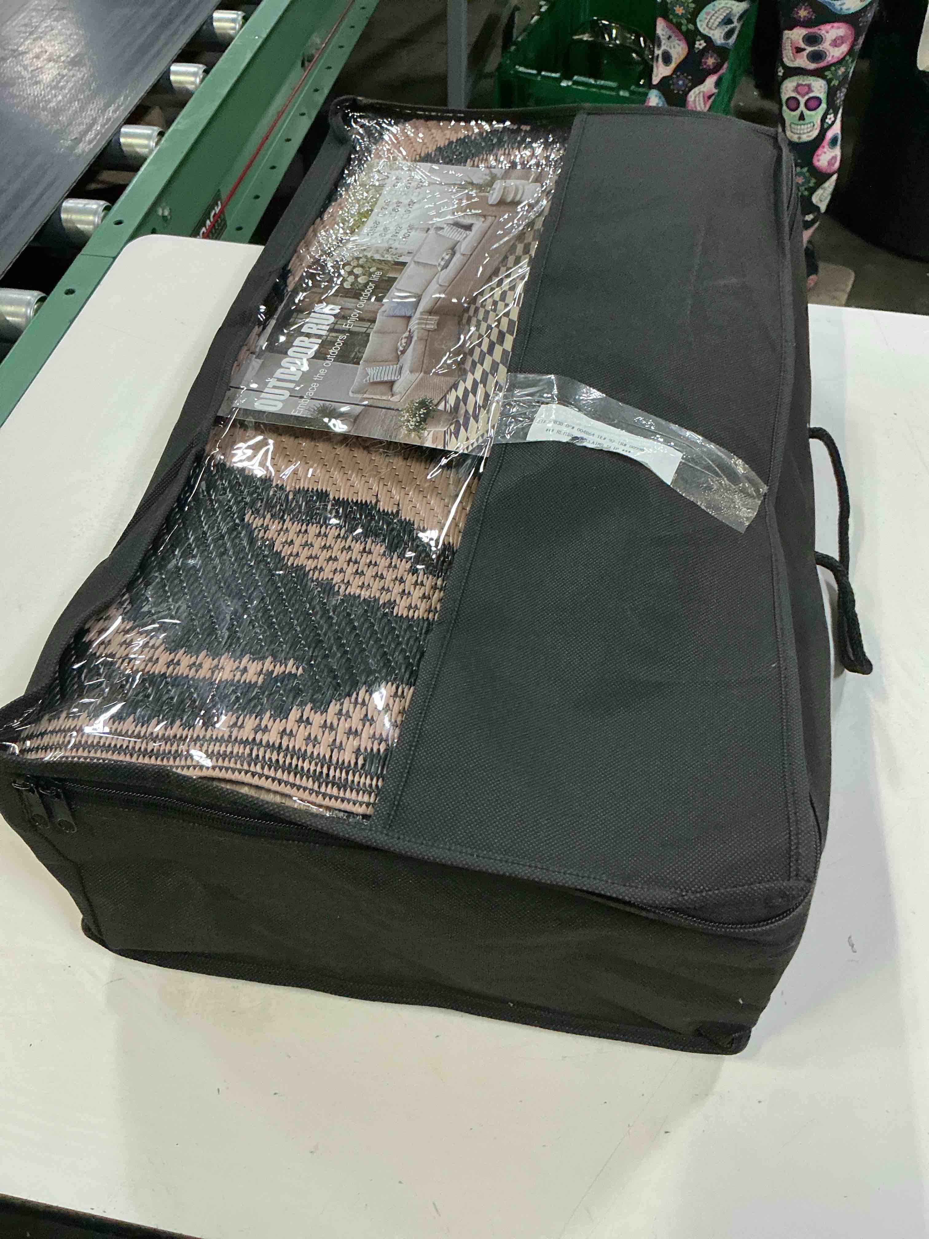 Condition photo showing New/Like New for reversible plastic straw outdoor rug featuring a black and beige floral pattern 8’x10’