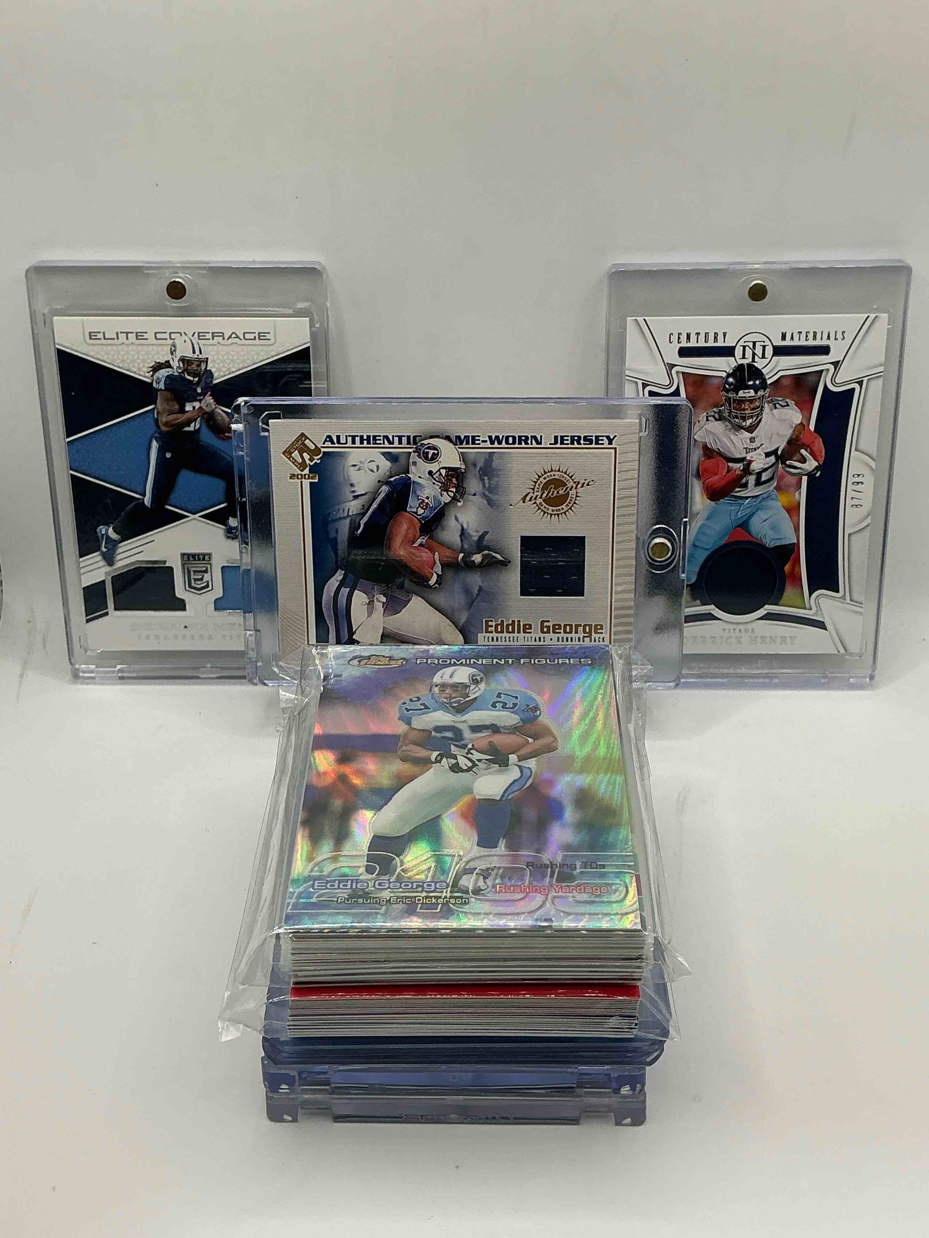 Tennessee Titans Surprise! 2002 Pacific Private Stock Game-Worn Jersey Patch Eddie George! 2022 National Treasures Football Century Materials Patch Derrick Henry Numbered 87/99! 2017 Donruss Elite “Elite Coverage” Dual Patch Derrick Henry! Along With 50 Other Titans Heroes, Legends, Rookies & Commons!