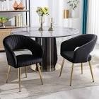 Set up two upholstered black velvet chairs with gold legs