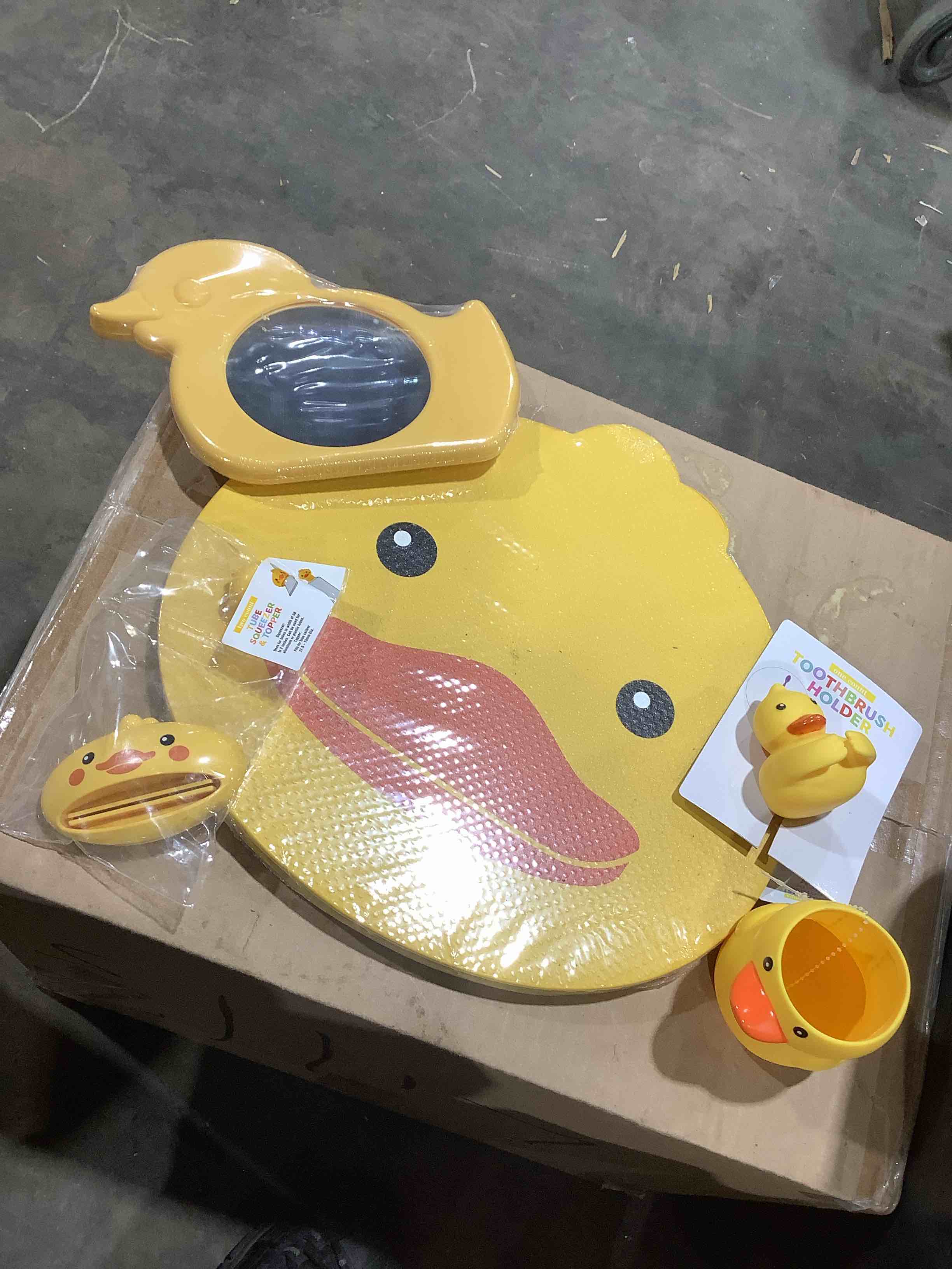 Yellow duck bathroom bath items: Toothbrush cover, kneeling pad, mirror, drink cup and tube squeeze and topper