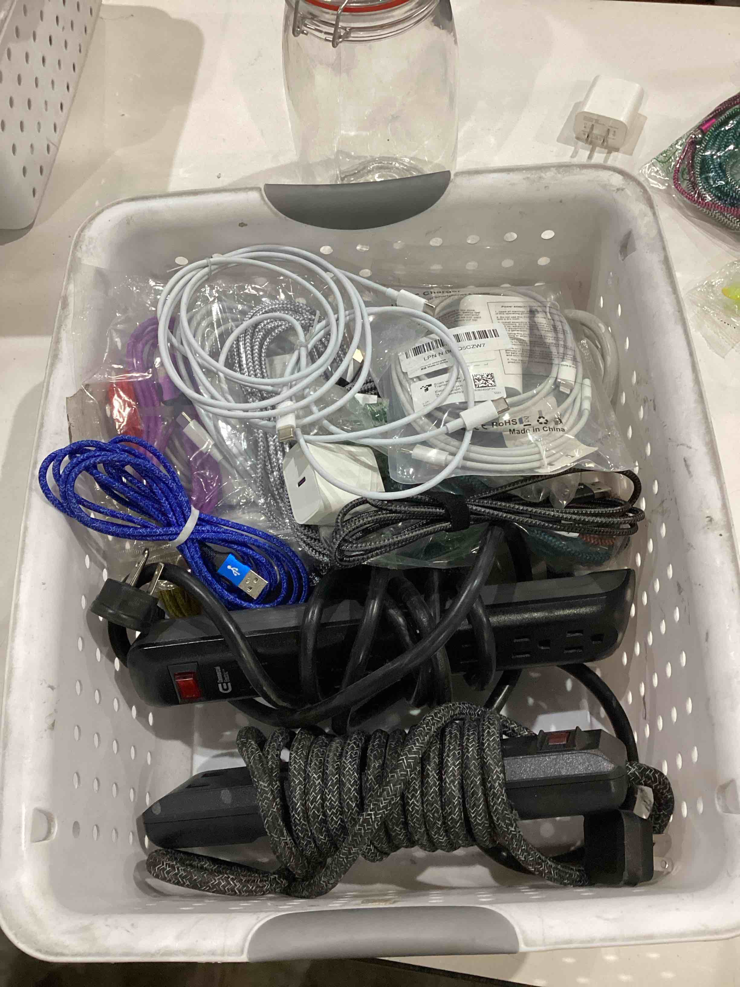 Condition photo showing As Is for basket of chargers, surge protectors, and extension cords.