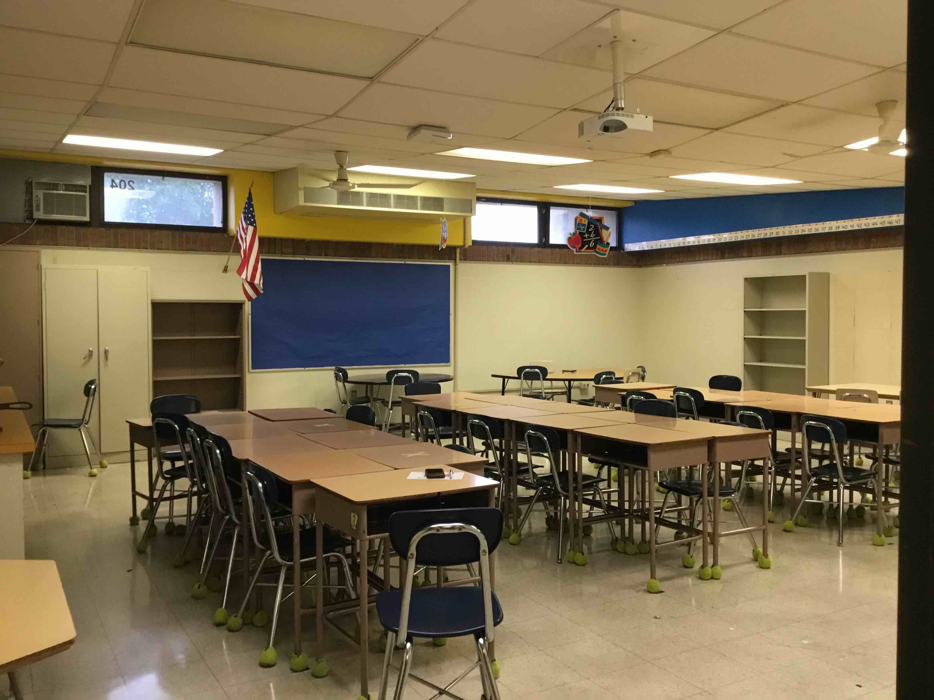 School Classroom 204 Contents To Include Desks, Tables, Office Chairs, Chalk Boards, Tack Boards, Filing Cabinets, Clock, Shelving Units, Ceiling Fans, Air Conditioner, Mobile Projector And Cart, Paper Cutter, Pencil Sharper, Wall Hand Sanitizer, Projection Screen and Map, And Doors (Promethean Board and Casio Projector, Kidney Table Not Included) 