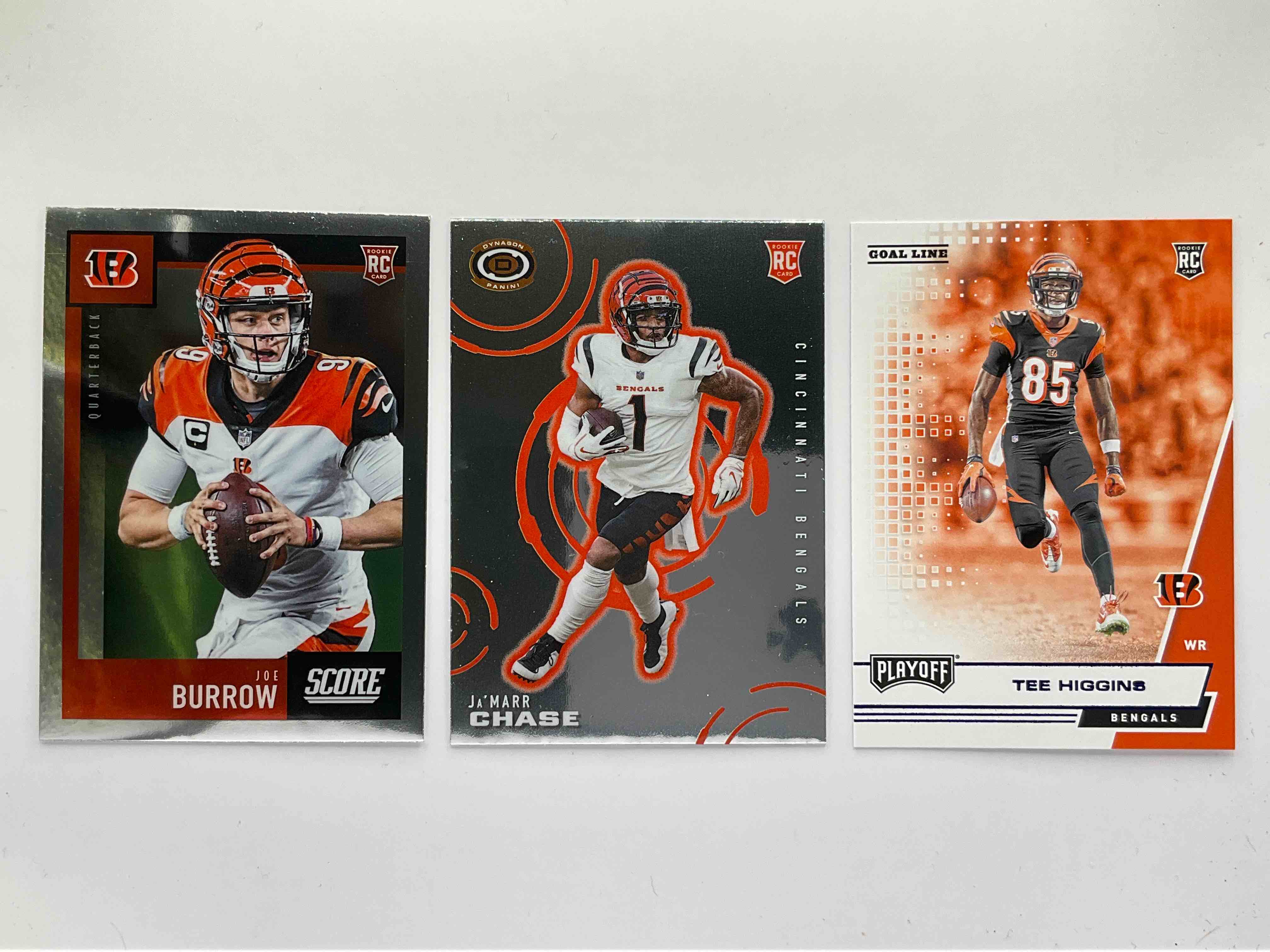 Who Dey Big Three Rookies!  Three Awesome Rookie Cards, Joe Burrow 2020 Score Chronicles, Ja’ Marr Chase 2021 Dynagon & Tee Higgins 2020 Panini Playoff.  All Rookies & All Mint!