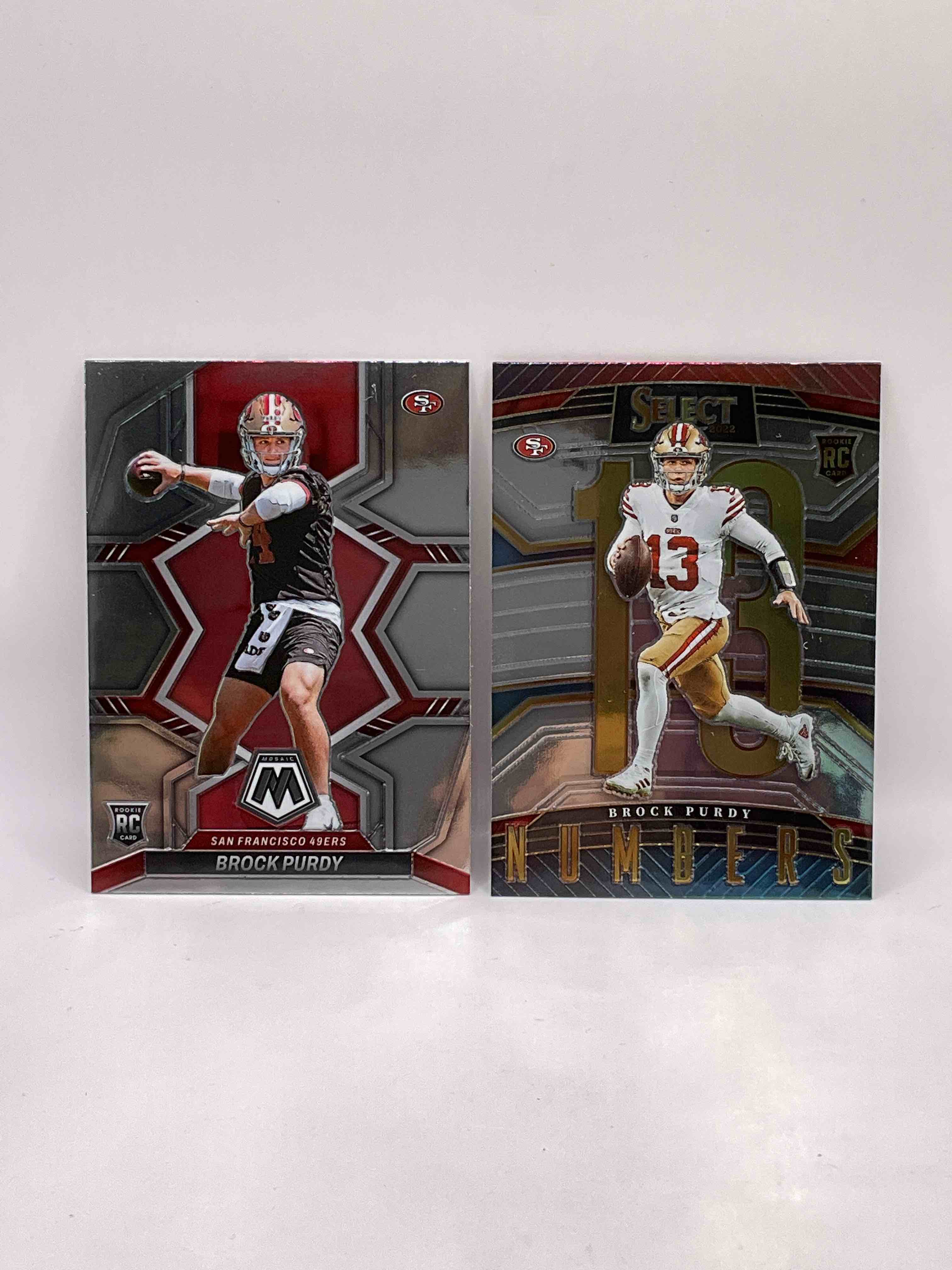 Here It Is! Now’s Your Chance To Own Two Incredible Rookie Cards From One Of The League’s Best! Brock Purdy Mosaic Rookie Card, Top Of The Line Rookie & Brock Purdy Select “Numbers” Rookie Card! Skyrocketing Value! Get Them While You Can!