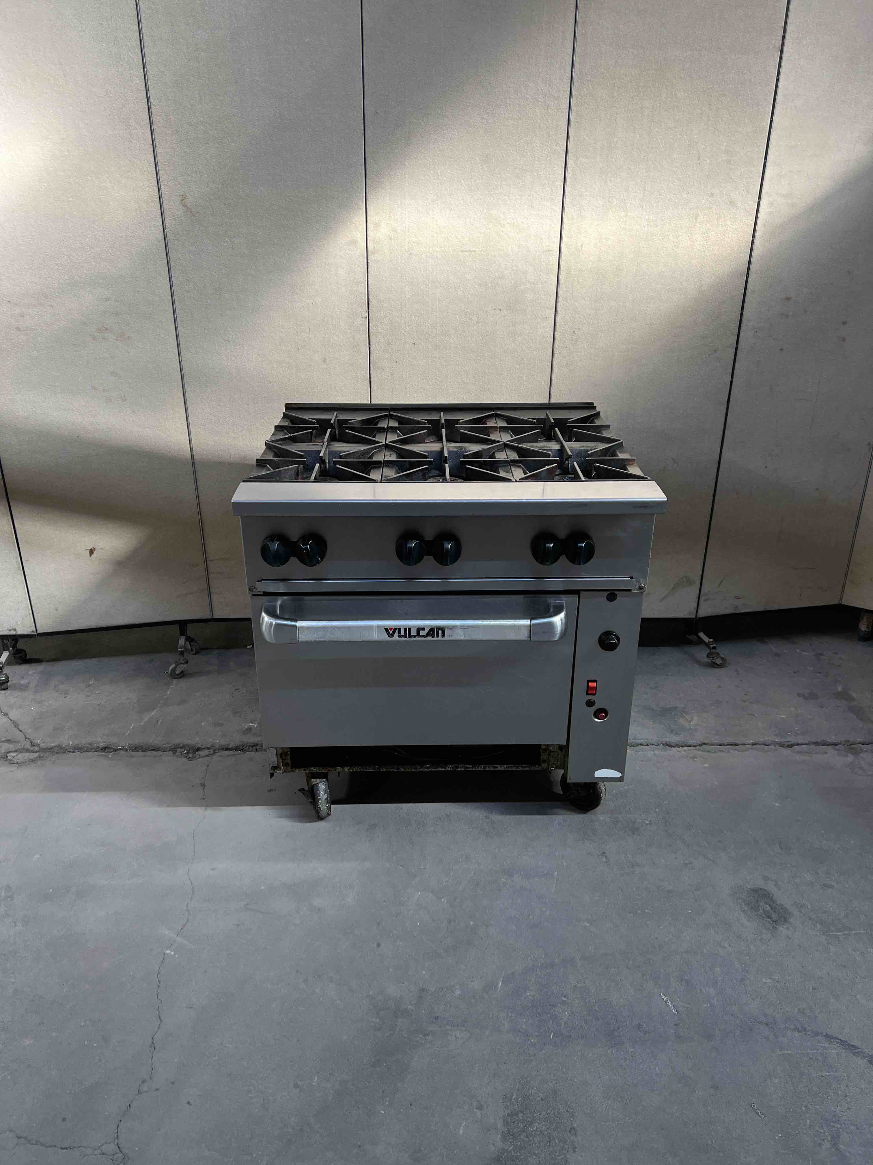 VULCAN NATURAL GAS SIX BURNER RANGE WITH CONVECTION OVEN ON CASTERS 