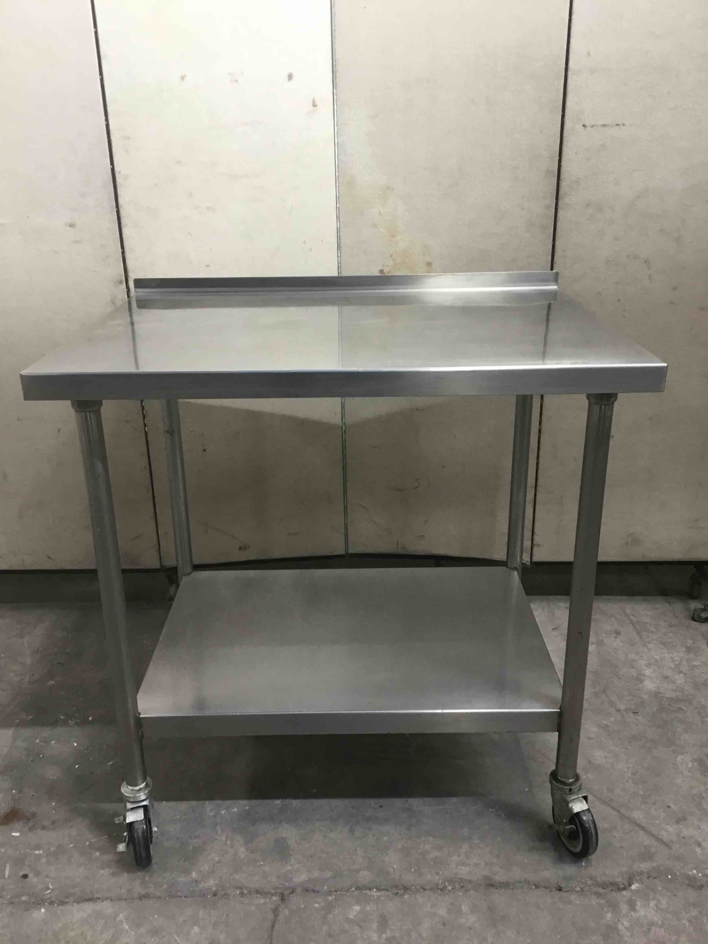 STAINLESS STEEL TABLE WITH UNDER SHELF ON CASTERS 